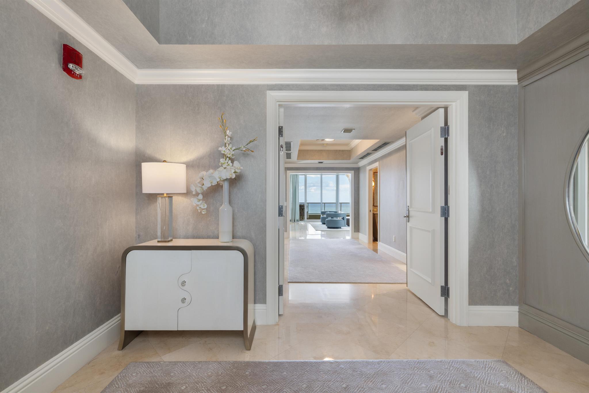 Experience refined coastal living at Ocean's Edge, one of Singer Island's most exclusive addresses. This fully renovated southeast corner residence by Jackie Armour Design (JMA Interiors) captures panoramic ocean and Intracoastal views through floor-to-ceiling glass and elevated ceilings. Offered furnished, the home features an elegant gallery entry, spacious living and lounge areas, and three bedroom suites with bespoke finishes. Custom cabinetry, designer fixtures, and curated textures define its modern luxury. Residents enjoy private elevator entry, resort-style amenities including pool, fitness center, theater, and club lounge--all within a serene, pet-friendly enclave.