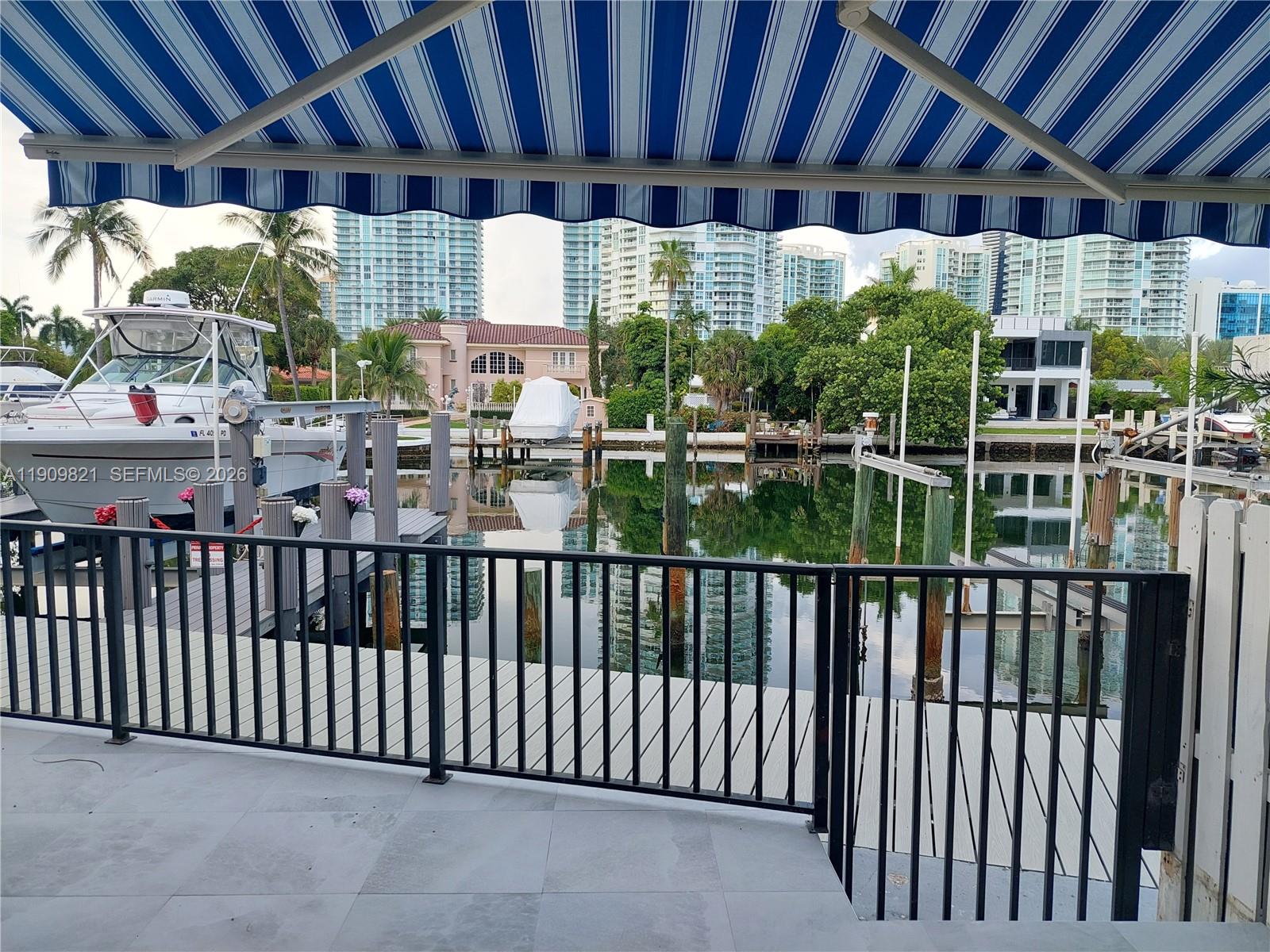 With a deed 30'-35' dock to shelter your boat, a Spacious Waterfront Townhome on Poinciana Island. Gated, 3 car parking, 3 bed, 2.5 bath townhome with vaulted skylight ceilings, kitchen, marble floors, and a patio with slate floors and water views. one car garage plus assigned front parking. New roof, impact front door, airy, light-filled interiors. The ocean is across the street. Resort-style amenities include two pools, tennis courts, gym, clubhouse, and 24/7 gated security with patrol.  Water, sewer and trash included. HOA pays insurance, cable, and internet. Island-wide high-speed wireless connectivity, Enhanced security with cameras in all plazas, garages, and along the boardwalk, The location is unbeatable: just 15 minutes by boat to the Bal Harbour Inlet and sandbar and Aventura mall is 15 minutes away.