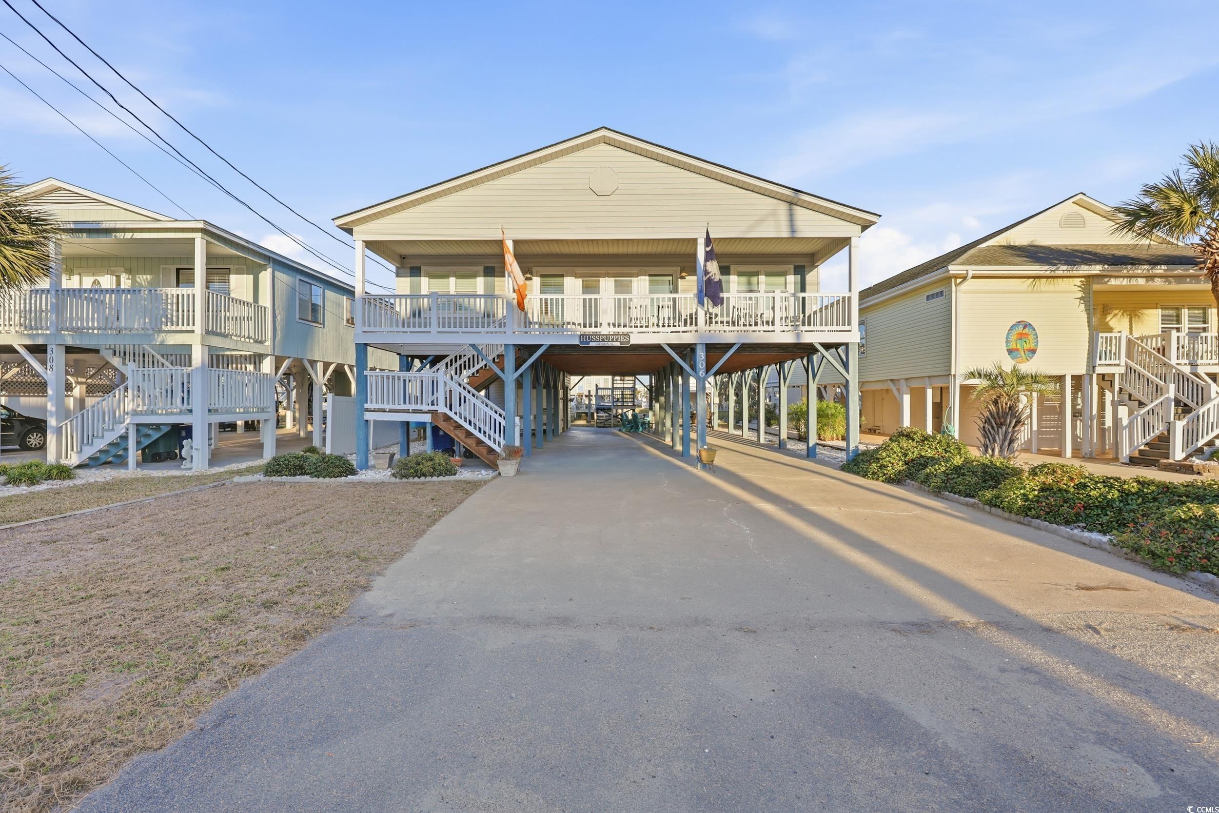 View of building exterior with a carport, stairs, and concrete driveway