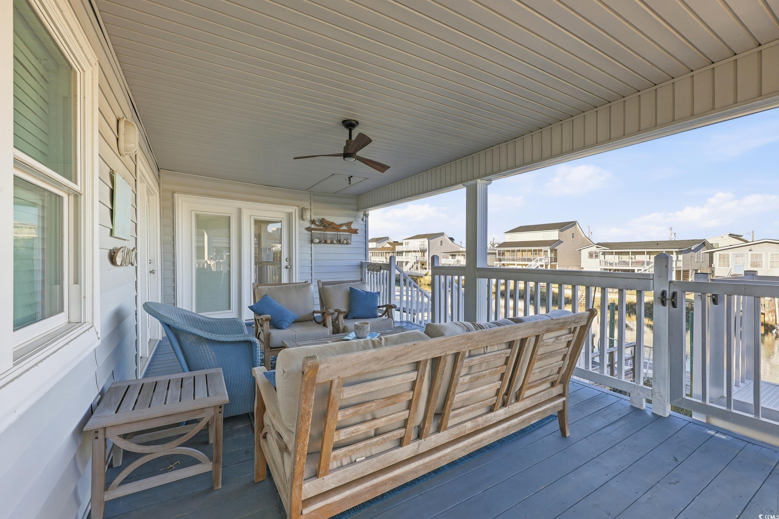 Wooden deck featuring a ceiling fan, an outdoor hangout area, and a residential view