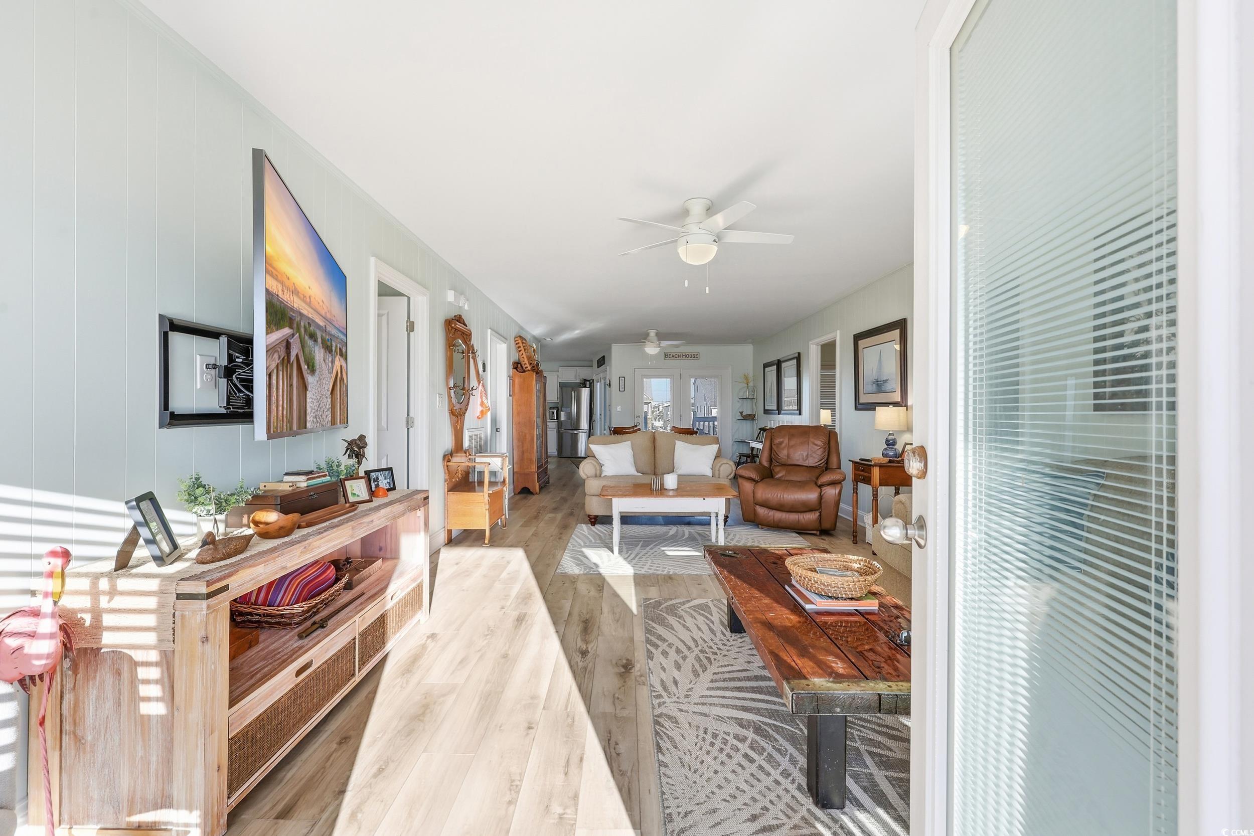 Living area with wood finished floors and ceiling fan