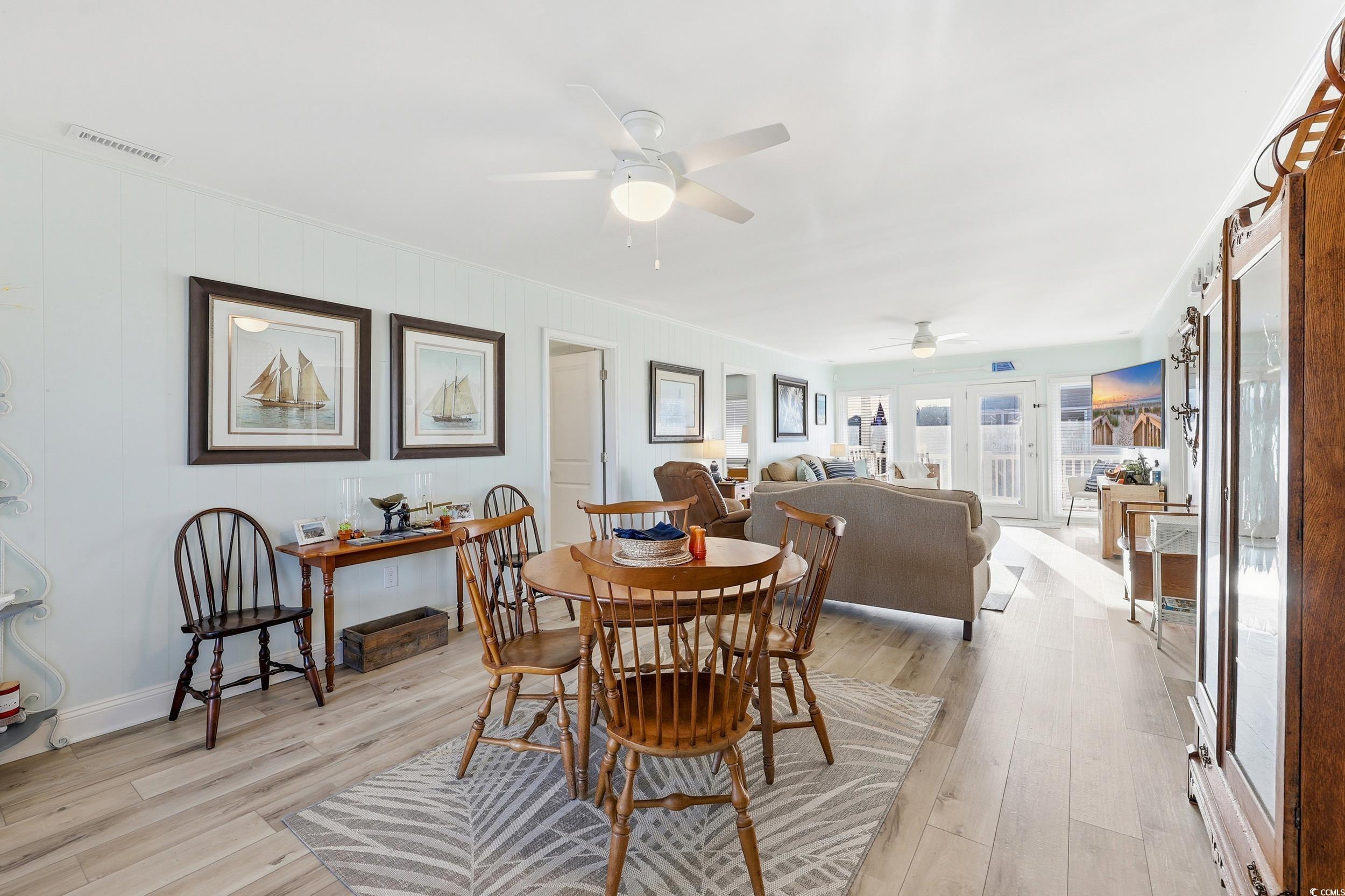 Dining room with light wood finished floors and ceiling fan