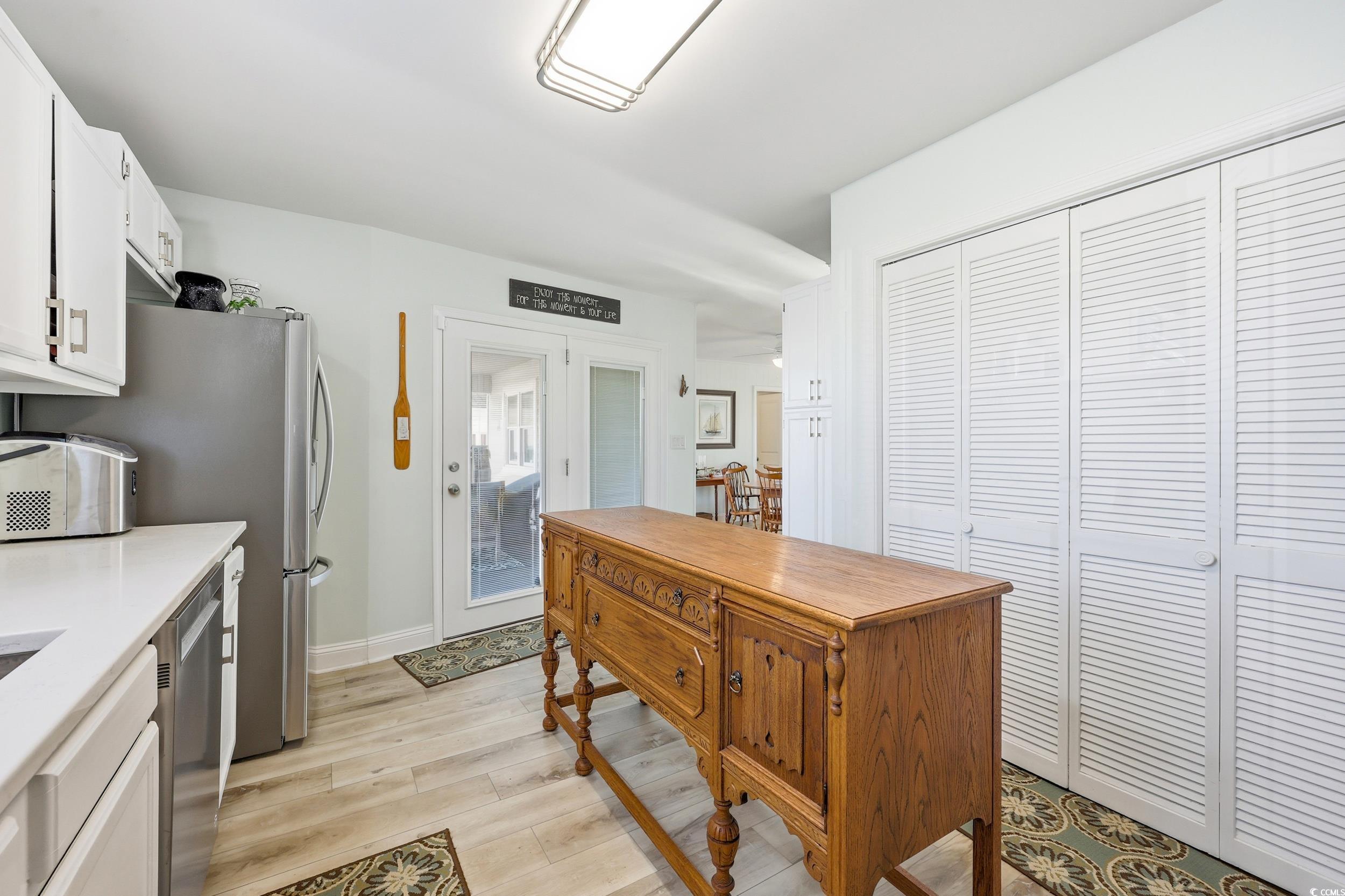 Kitchen featuring white cabinetry, light wood-type flooring, and dishwasher