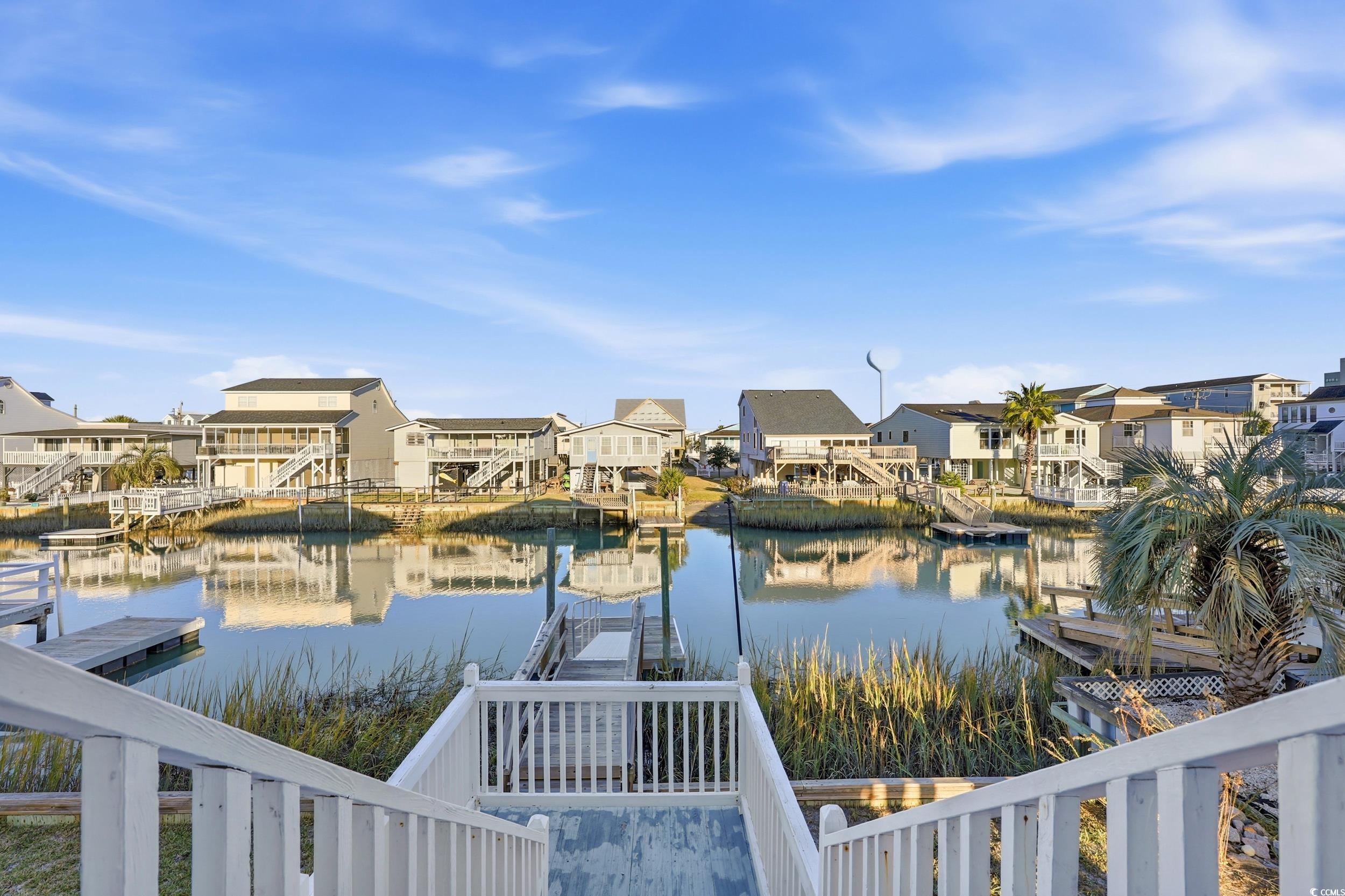 Water view featuring a dock and nearby suburban area