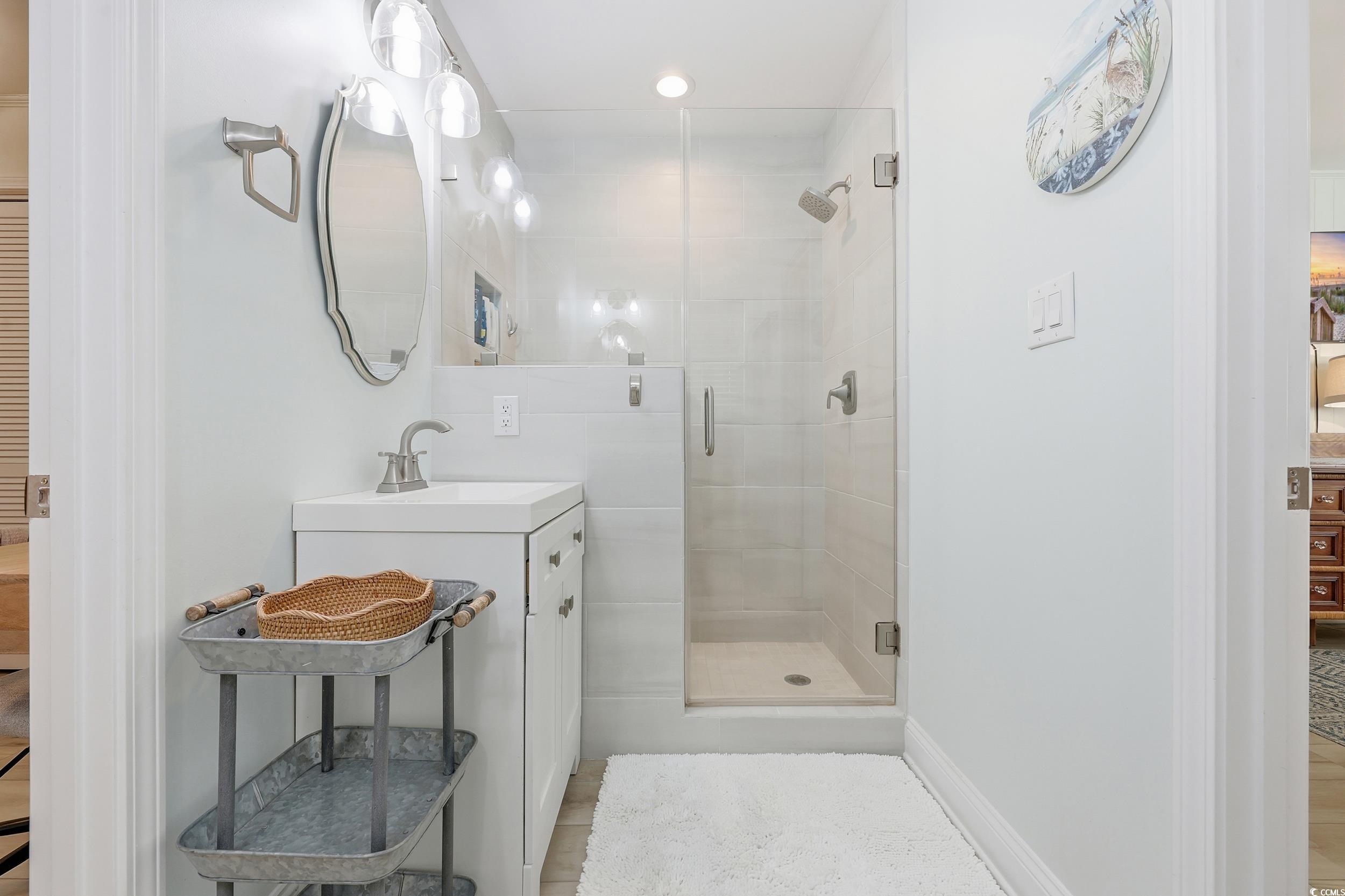 Full bathroom featuring vanity, a shower stall, and recessed lighting
