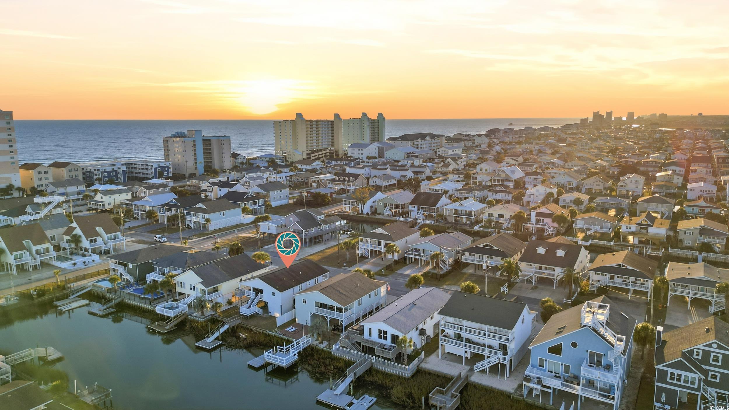Aerial perspective of suburban area featuring a nearby body of water