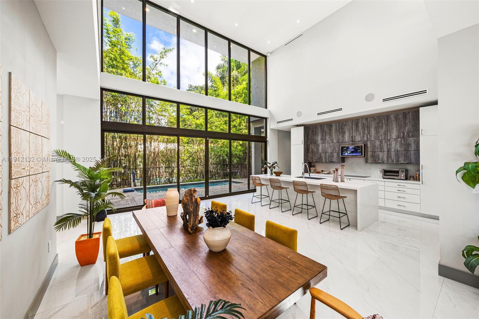 Modern 2-story pool home in South Coconut Grove near top restaurants, entertainment & the best Miami schools. Built in 2020, this 5-bed 4.5-bath 5,259-SF home offers 6,412 total SF of thoughtful design with beautiful finishes & seamless indoor-outdoor flow. A double-height kitchen/dining area overlooks the pool through stacking sliding glass doors that open fully for effortless entertaining. The eat-in kitchen features a large chef’s island & stainless-steel appliances. The main floor includes an ensuite bedroom ideal for guests. Upstairs boasts 4 bedrooms including the primary suite with a private balcony, spacious bathroom & an open den perfect for an office. The covered patio extends the living space with a summer kitchen & dining area beside the pool. 2-car garage completes the home.