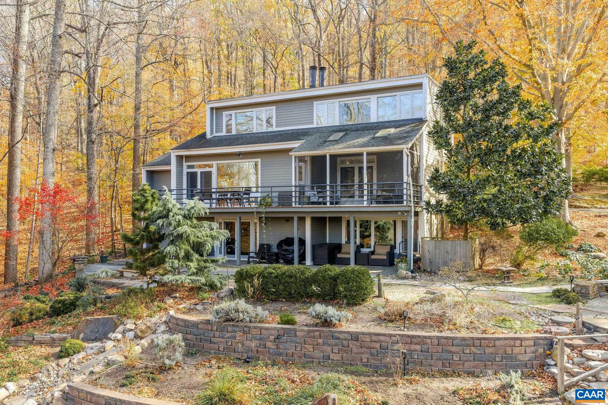 A rare gem designed by renowned UVA architectural professor Jim Tuley, this striking contemporary home sits atop 30+ private acres with sweeping Blue Ridge Mountain views. Walls of glass fill the home with natural light and frame the stunning landscape. Highlights include a remodeled kitchen, newly updated bathrooms, and a primary suite with a soaking tub overlooking the mountains. The property features beautiful gardens, mature plantings, fruit trees, a koi pond, stunning stonescape and a versatile barn/art studio ideal for creative or functional use. With solar power, a newer whole-house generator, and division potential, this private retreat combines architectural sophistication, sustainability, and investment opportunity—just minutes from Charlottesville.