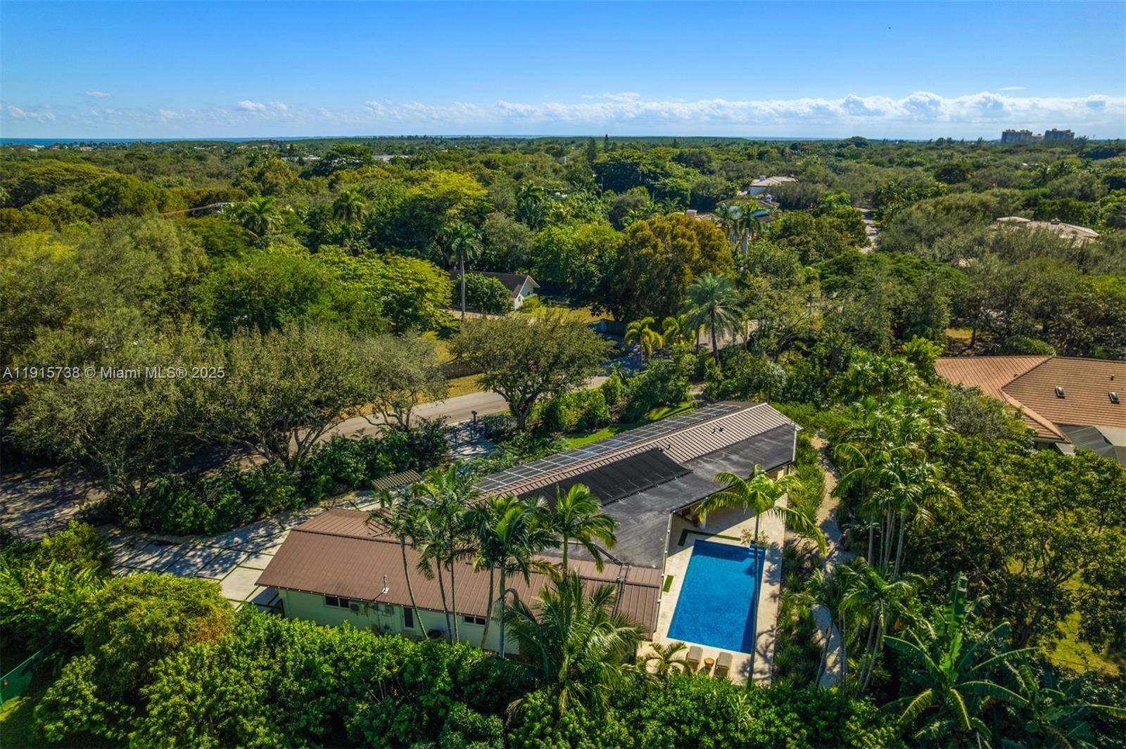 This fully renovated contemporary estate in the heart of Pinecrest offers 3,191 SF of refined living on a 26,963 SF lot. Flooded with natural light, the home features impact windows, plantation shutters, and large-format grey porcelain tile floors. The open kitchen showcases Italkraft custom cabinetry, striking grey quartzite countertops, and premium appliances. A serene primary suite includes a spacious walk-in closet and a spa bath. Outdoor living shines with a sprawling covered terrace and a breathtaking naturalistic grotto waterfall and emerald pool, complemented by a saltwater heated pool, lush landscaping designed by Raymond Jungles, solar panels, and an AC-equipped 2-car garage.