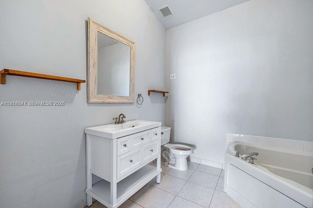 Well-appointed guest bedroom at 2437 Coral Trace Cir - Townhouse in Delray Beach