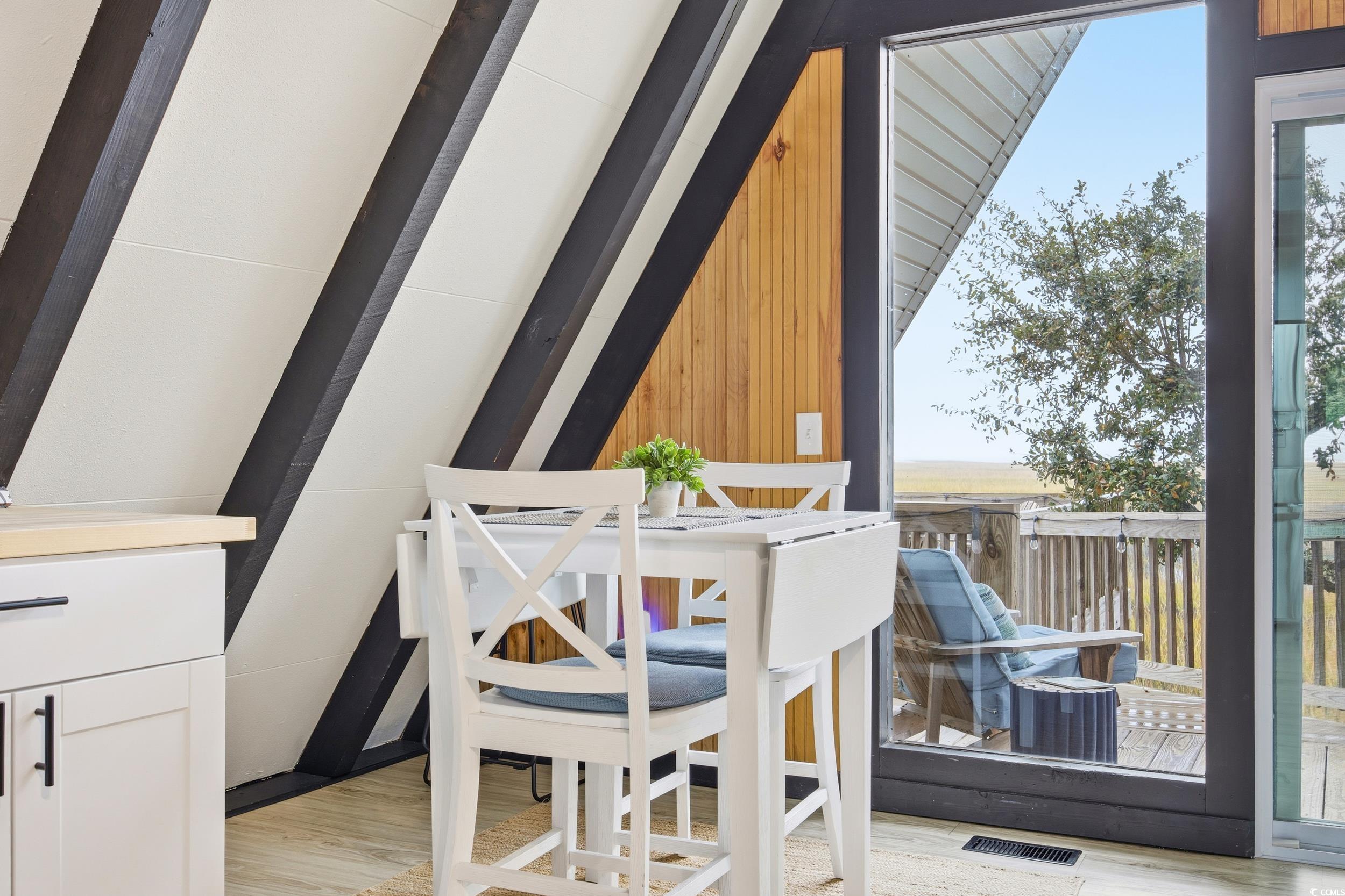 Dining space with light wood-type flooring and wooden walls
