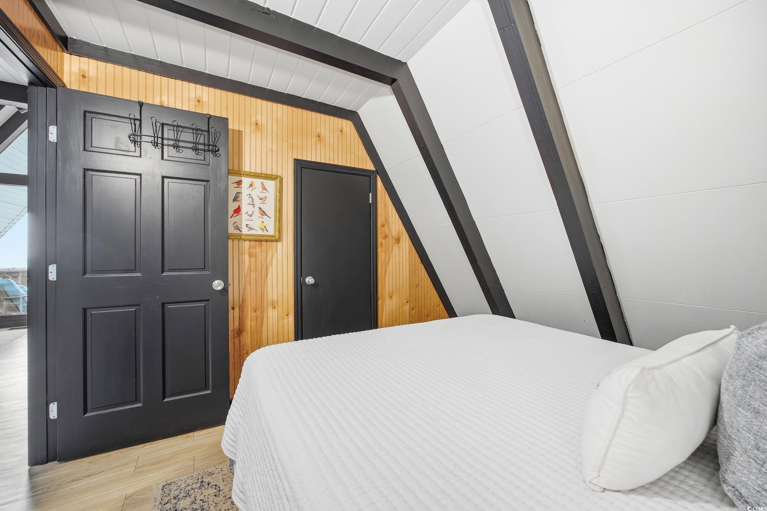 Bedroom featuring wooden walls and wood finished floors