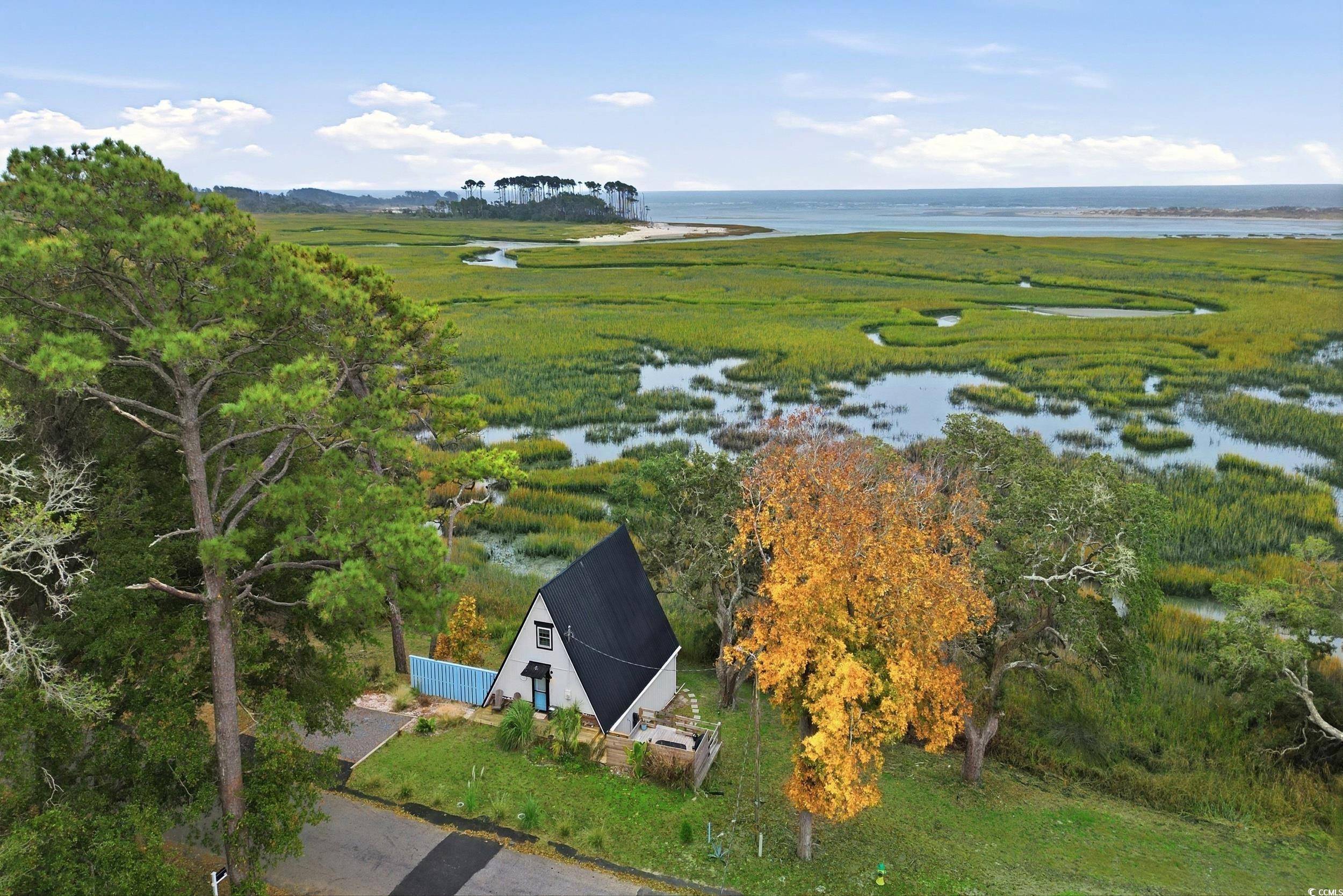 Aerial view of property and surrounding area with a nearby body of water