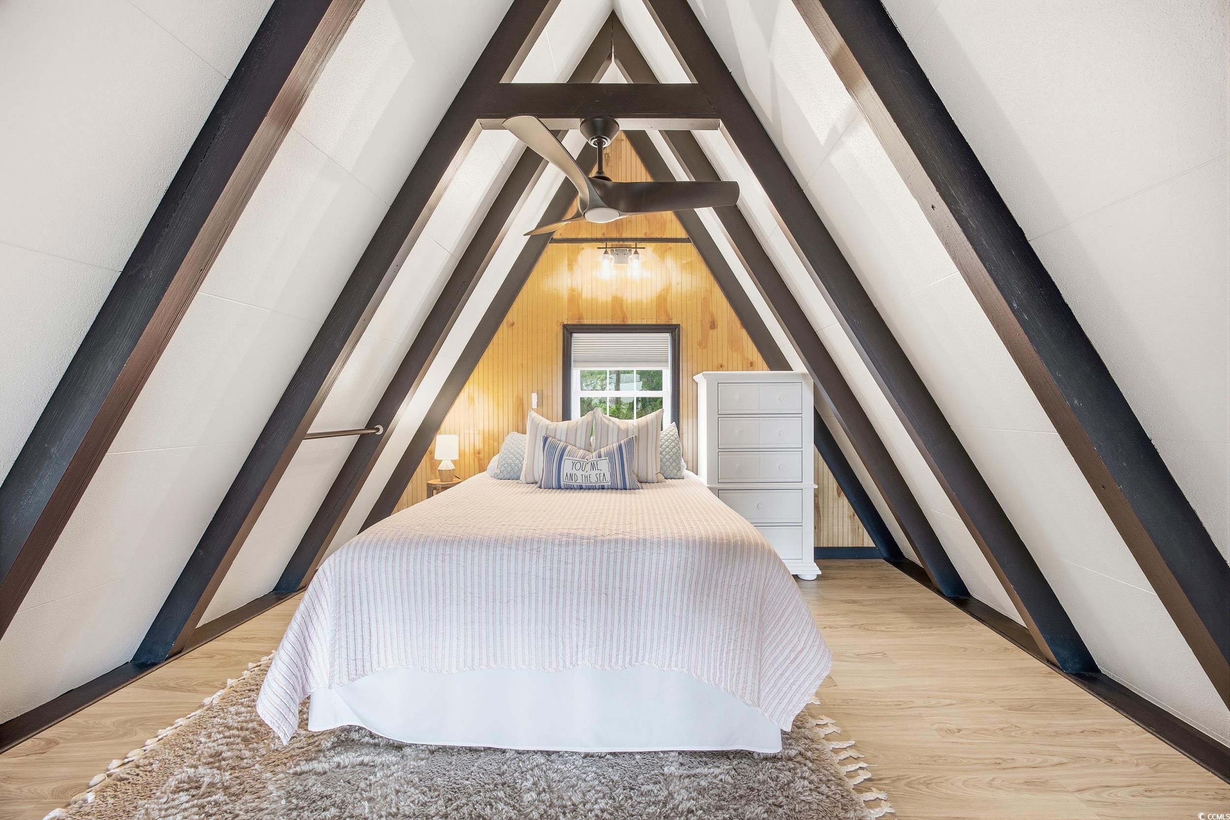 Bedroom featuring wooden walls and wood finished floors