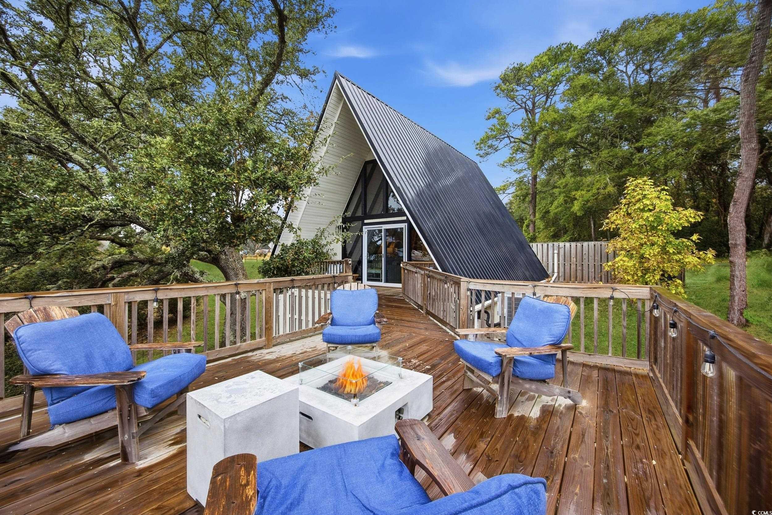 Wooden deck featuring an outdoor fire pit and a sunroom