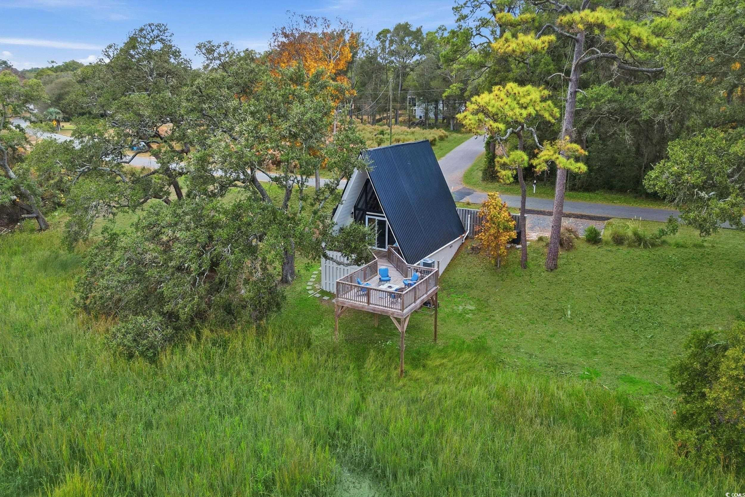 Aerial view of property and surrounding area with a tree filled landscape