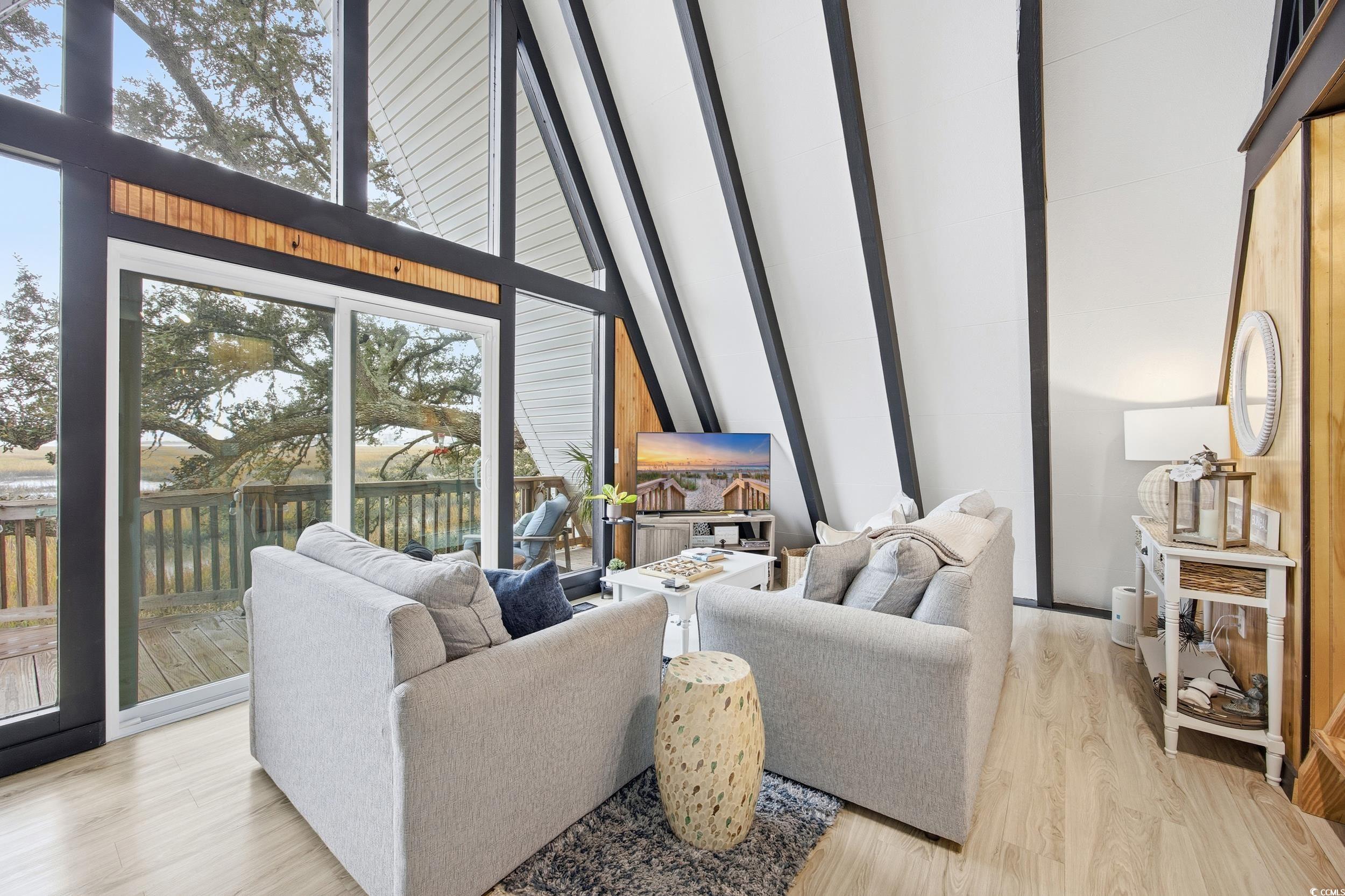 Living area with a towering ceiling and light wood-style flooring