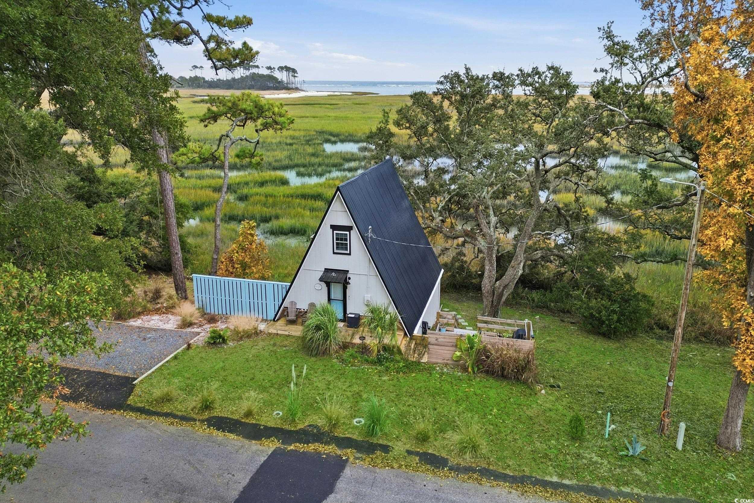 View of front facade with a water view and a front lawn
