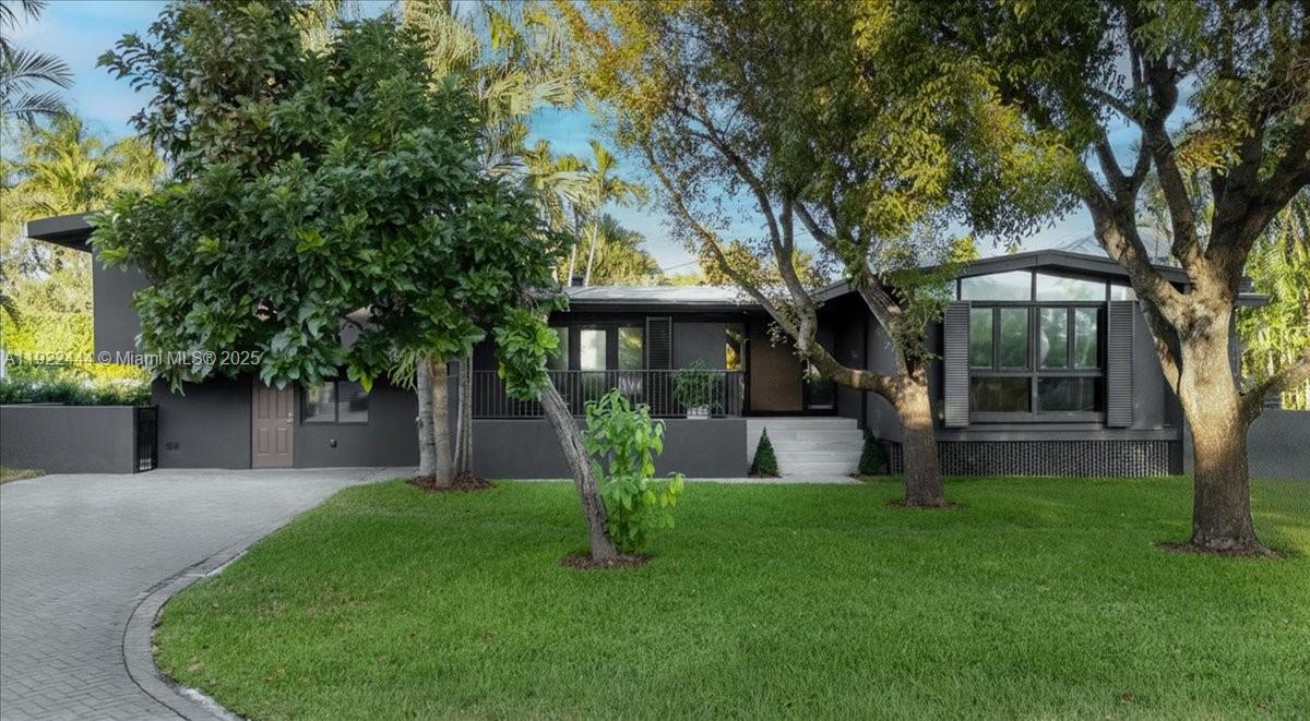 A beautifully reimagined home on one of Key Biscayne’s most desirable streets, South Mashta Drive. With its bold charcoal façade and distinctive presence, this residence stands out immediately while maintaining a warm island charm that makes it feel welcoming from the moment you arrive. Surrounded by mature trees and lush greenery, the setting offers both atmosphere and privacy.Inside, vaulted ceilings and expansive windows fill the space with natural light, creating a soft and inviting ambiance. The great room features a stone fireplace, wide-plank wood floors, and a natural flow to the terrace and pool, bringing effortless connection between indoor comfort and outdoor enjoyment. Every space reflects a carefully curated, cozy feel that enhances the character of the home.The renovated master bathroom offers calming finishes and a serene atmosphere. A private suite provides the perfect accommodation for guests or extended family. Set on a generous 10,000 sq ft lot and enhanced with impact windows, updated lighting, a newer roof, and thoughtful design details, this residence blends timeless appeal, warmth, and the unique island charm that defines Key Biscayne living.A rare opportunity to own a home that feels both distinctive and deeply inviting, in one of the most coveted locations on the island.