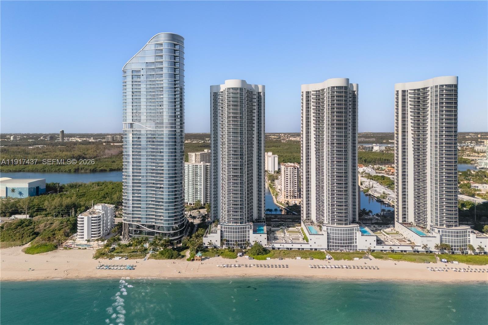 High floor, direct oceanfront, fully furnished residence in the highly desirable 07 line at Trump Tower III. This 2 Bedroom + oversized Den with en-suite Bath (lives as a 3rd Bedroom) offers a private elevator entrance and foyer, 11-ft ceilings, and floor-to-ceiling impact glass with direct ocean, Intracoastal, and Miami skyline views. Spacious living and dining areas flow seamlessly toward the terrace, creating a bright, open layout ideal for everyday living and entertaining. The living room is adorned with a custom TV wall, custom light fixtures, and decorative wallpaper. The primary bedroom offers direct balcony access, a large built-out walk-in closet, and an impressive spa-like bathroom. The second bedroom's closet was expanded, as was the den's, which both include their own en-suite bathrooms, offering true bedroom functionality. All bathrooms are finished with contemporary fixtures including floating vanities, marble floors, and glass-enclosed showers. Additional interior features include walk-in closets, built-ins, walk-in laundry room, and a large primary suite with separate tub and shower. Flooring is luxurious travertine throughout. Residents enjoy direct beach access with full chair/towel service, heated oceanfront pools, seaside restaurant with room service, fitness center, spa, business center, clubroom, concierge, and valet. A high-floor beachfront residence with panoramic views and modern upgrades in one of Sunny Isles’ premier towers.