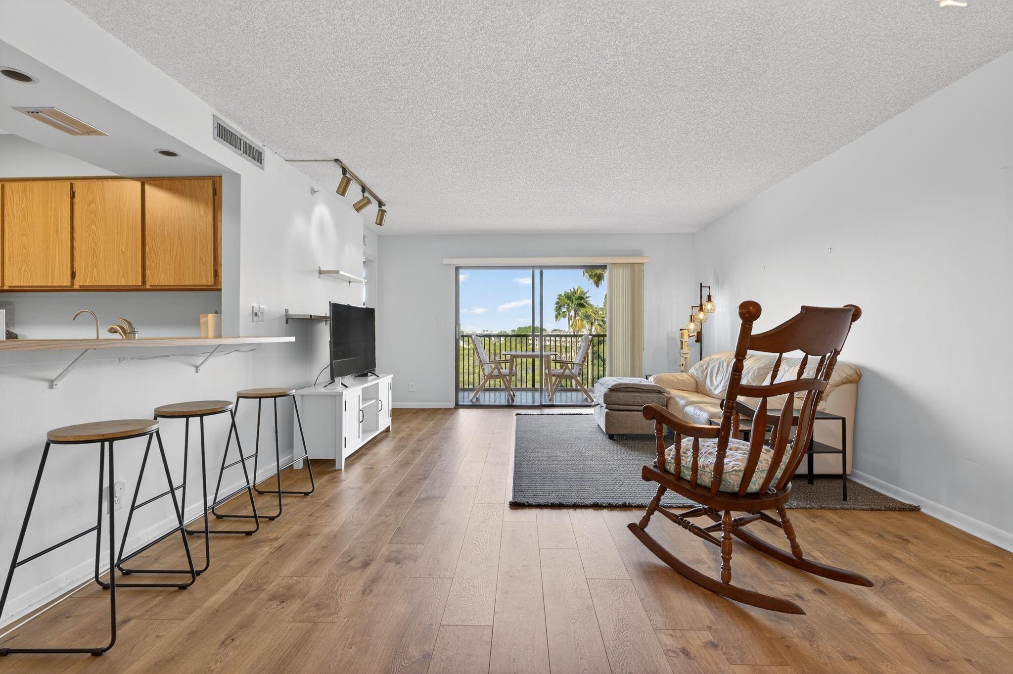 Light pours into this bright, beautiful living room, where you’re greeted with views of the pool, lake, and lush gardens. It’s the kind of space that just feels good the moment you walk in—airy, open, and full of natural charm.
