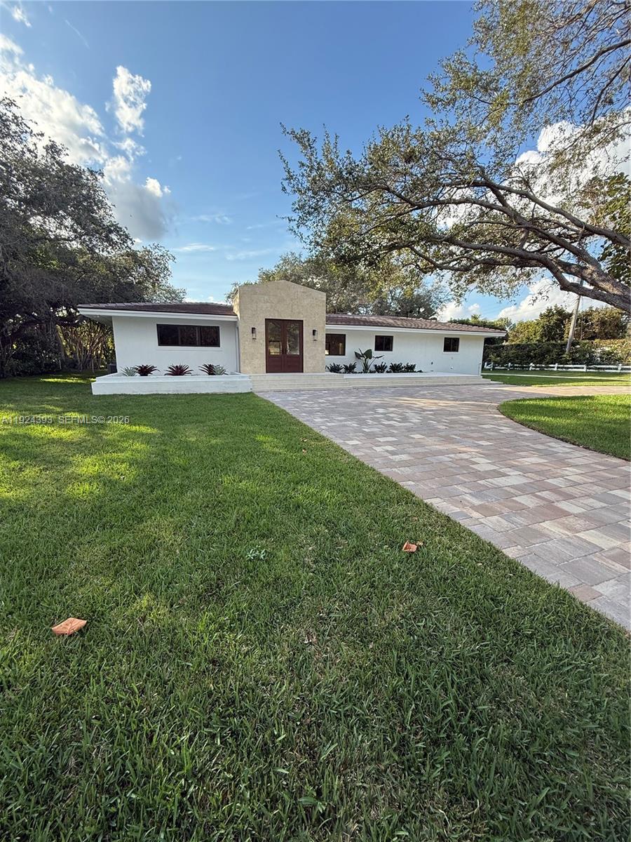 Completely renovated modern estate on an expansive corner lot in desirable Pinecrest. Stripped to the shell and rebuilt, Fully reimagined and Reconstructed from the inside out, Every detail is brand-new including electrical, plumbing, roof and impact windows and doors throughout. 3862sqft living area, as per recent appraisal. This home blends modern luxury with warm natural finishes, offering an elegant, open-concept design throughout. This stunning 5 bedrooms and 4 bath home features a spacious open floor plan with vaulted ceilings, natural finishes, and abundant light throughout. The designer kitchen offers custom wood cabinetry, premium stone counters, an oversized waterfall island, induction cooktop, double oven, and full wall of pantry storage. The open layout flows into a bright and oversized family/dining/living space, perfect for entertaining. The primary suite includes a luxurious spa-style bathroom with double vanity, freestanding tub, and large glass-enclosed shower. 48x48 porcelain flooring throughout the main living areas, and beautiful natural wood flooring in all bedrooms. Additional flexible rooms are perfect for office, gym or playroom.Enjoy the oversized covered terrace with wood ceiling and modern fans, Newly built pool with safety net, and a spacious backyard surrounded by mature trees for privacy. Long paver driveway with ample parking. Beautifully remodeled and move-in ready, located in one of Pinecrest’s most sought-after neighborhoods.