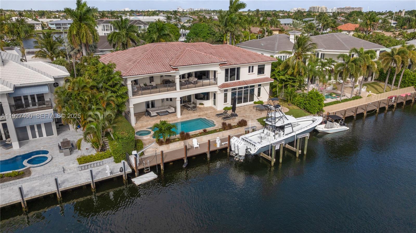 Welcome to the ultimate boater’s estate in Lighthouse Point. Situated on a prestigious cul-de-sac, this Mediterranean residence sits on a massive turning basin, offering expansive water views and effortless maneuverability for large vessels. The property features 100 feet of water frontage with no setbacks and a brand new 32,000 lb Hurricane boat lift.Enter through double doors to soaring ceilings, travertine flooring, and water views from the moment you step inside. The floor plan is designed for multi-generational luxury, featuring a residential elevator and dual laundry centers (upstairs and down). The kitchen was recently refreshed with new quartz countertops, opening to a spacious family room. The first floor hosts two guest suites, including a VIP suite with a fully remodeled 2024 ensuite bath and walk-out pool access.Upstairs, discover a dedicated executive office, a remodeled morning bar/coffee lounge, and a gym (or additional bedroom) with a private balcony. The exterior is an entertainer's paradise featuring a sprawling covered loggia, summer kitchen, heated pool, and spa. Recent Upgrades: Full-home Generac generator, impact windows/doors, 1 new A/C unit (2025), new landscaping, 3-Car Garage. Unbeatable value on a street with neighboring $10M+ estates.