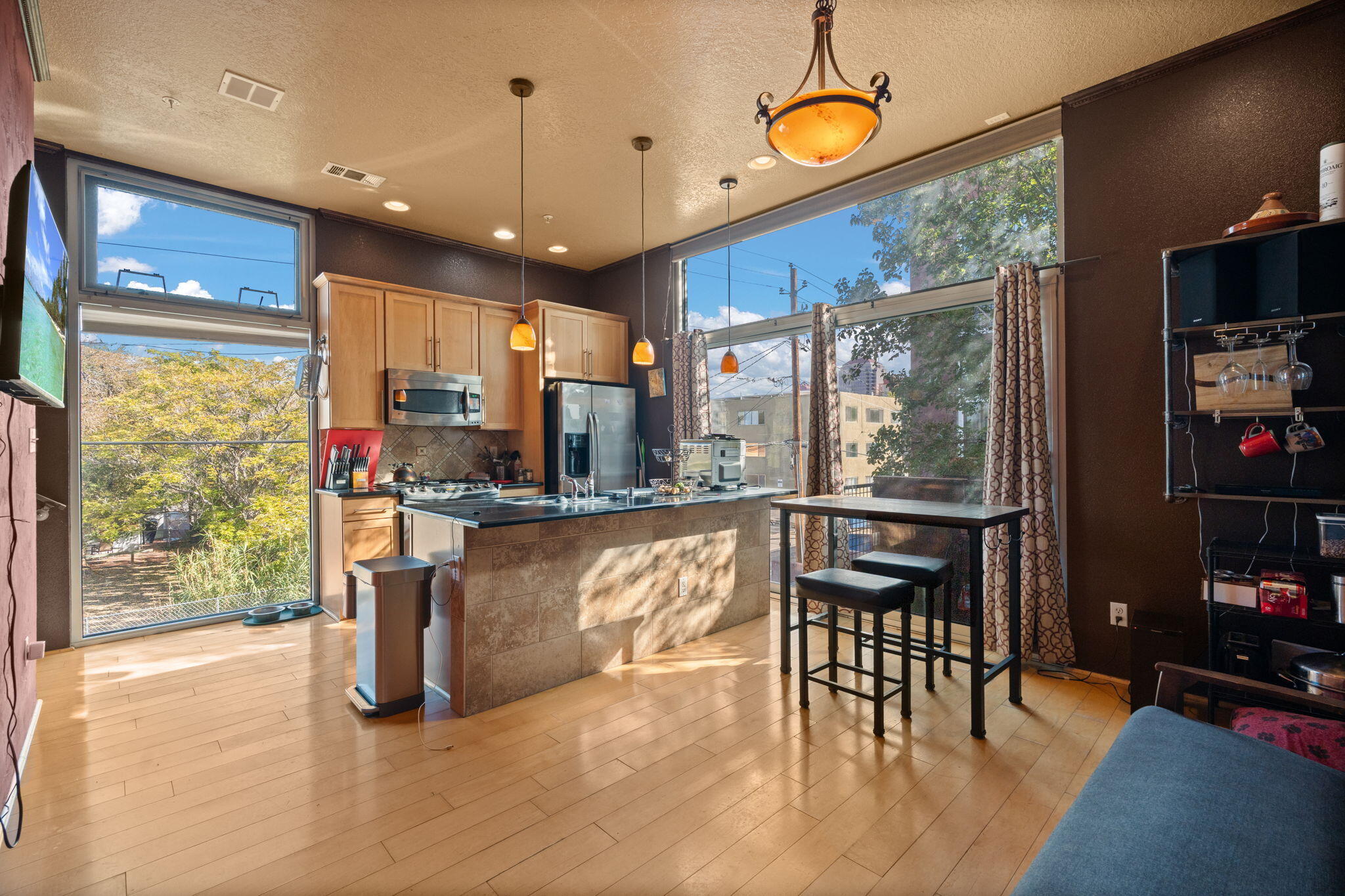 Modern 3-story townhome in gated Downtown ABQ with low HOA. Bright layout features bamboo floors, refrigerated air, and floor-to-ceiling windows with city views overlooking the courtyard. The flex space on the main level is ideal for additional living area, office, or art studio. Gourmet kitchen with stainless appliances and granite counters. Third-floor suite includes a balcony, two closets, jetted tub, and in-unit laundry. Private ground-level courtyard and contemporary design throughout. Convenient access to Downtown amenities, Old Town, parks, the zoo, and major roads.