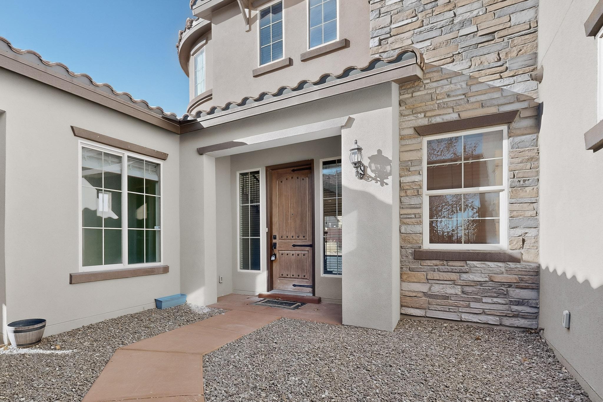 Beautiful two-story home in a gated community on an oversized lot with an open, light-filled floor plan. The kitchen features granite countertops, custom hardwood cabinetry, and a large island, opening to a living area with soaring 20-foot ceilings and picture windows.The main-level primary suite offers his & hers walk-in closets, separate shower, tub, and  landscaped backyard with a covered porch, and a gas line for grilling. The main floor also includes an office, formal dining room, half bath, and a private casita with covered patio and outdoor gas fireplace.Upstairs features four bedrooms, two baths, and a loft with Sandia Mountain views. The home also has a 3-car garage, dual refrigerated air systems, new refrigerator (April), and new oven. and a washer and dryer!