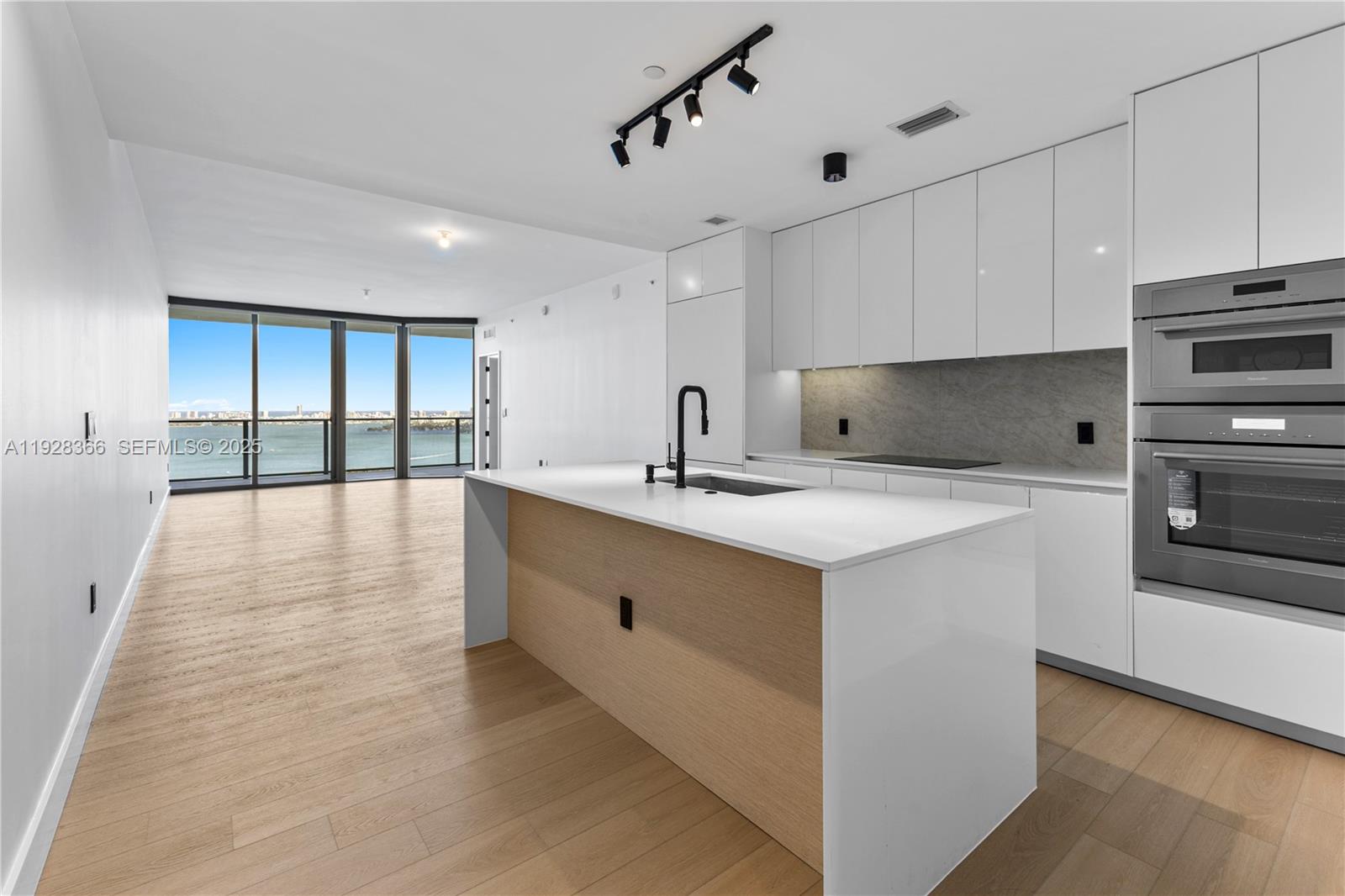 Residence 2905 at Aria Reserve South is a renovated, east-facing 3 bedroom plus office with 3.5 baths and wide Biscayne Bay views. Private elevator entry leads to a spacious great room and a deep terrace for true indoor-outdoor living. More than $80,000 in owner upgrades include wide-plank floors, custom lighting, motorized blackout shades and sheers, and fully built-out closets. The reworked kitchen features sleek lacquer cabinetry, slab backsplash, induction cooktop, double wall ovens, a large waterfall island, and matte fixtures. Primary suite offers a spa bath with glass shower and freestanding tub; two additional bedroom suites provide excellent separation. Approximately 1,770 SF under A/C plus a 228 SF terrace (per developer). Aria Reserve South delivers a full lifestyle program: bayfront marina, resort spa, indoor/outdoor fitness, tennis and paddle courts, basketball, kids amenities, co-working lounges, concierge and valet. Prime Edgewater location near Design District, Wynwood, Brickell, Downtown and Miami Beach.