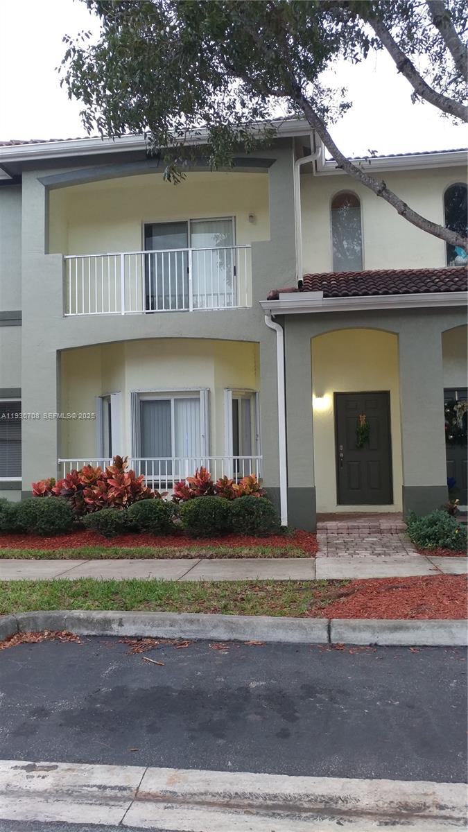Two Story Townhouse with garage and balcony, parking in rear and front of building. Association fee includes insurance for building exterior, internet and media, alarm service, gated community, use of pool and playground.