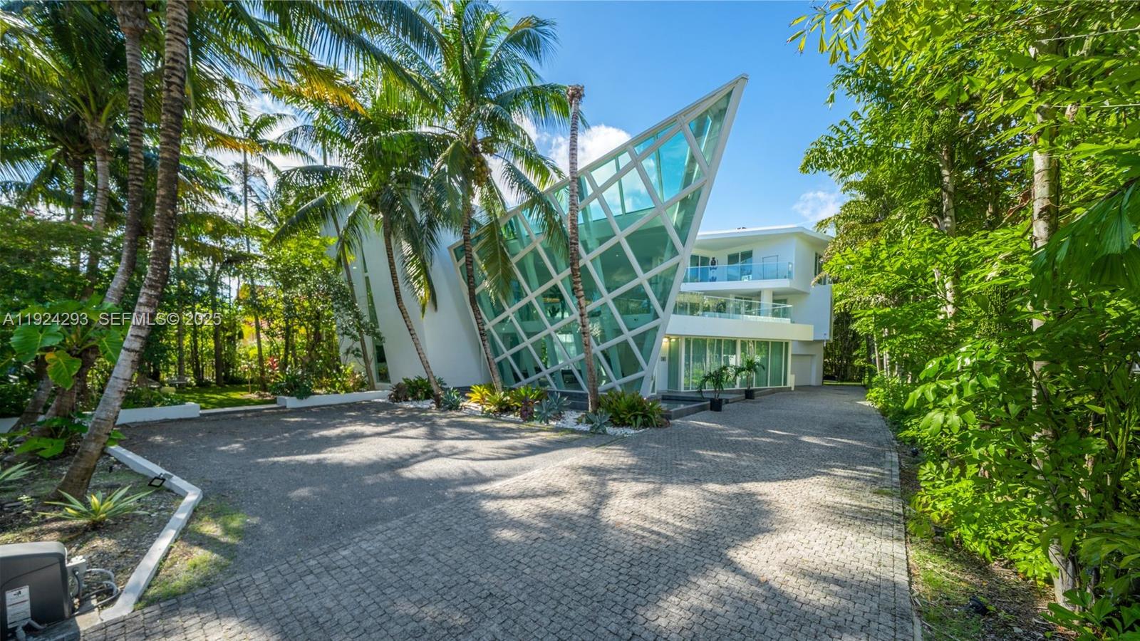 Set on an oversized 15,000 SF lot in the exclusive enclave of Golden Beach, this exceptional 3-story architectural masterpiece—known as The Ark—spans 7,249 SF and is celebrated for its iconic glass-shaped design. The residence features 6 bedrooms and 8 bathrooms, soaring 20-foot ceilings, an Italian chef’s kitchen, a fully integrated smart-home system, and an oversized primary suite. Expansive terraces throughout the home offer breathtaking ocean views. Designed for both entertaining and everyday living, the open-concept layout provides seamless indoor-outdoor flow. Lush tropical landscaping creates a private, resort-style retreat complete with a saltwater pool, summer kitchen, and multiple outdoor entertaining areas. Located just a short walk from Golden Beach’s residents-only beach pavilion, parks, and tennis/padel courts.