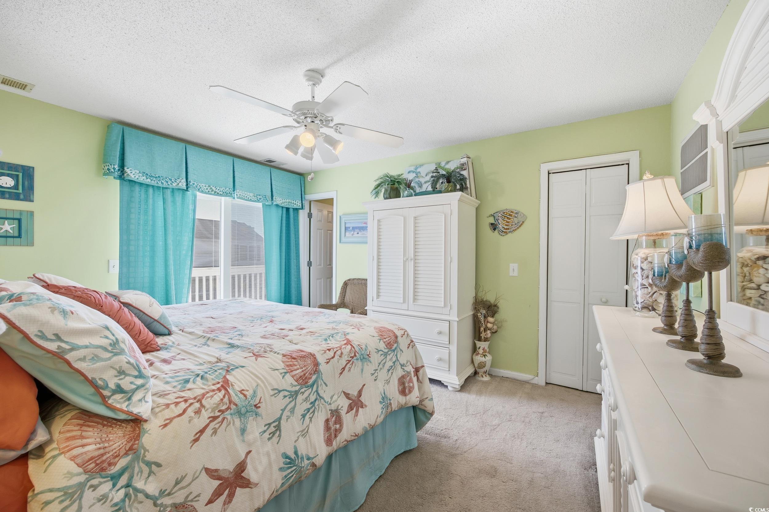 Bedroom featuring a textured ceiling, light carpet, access to outside, and ceiling fan