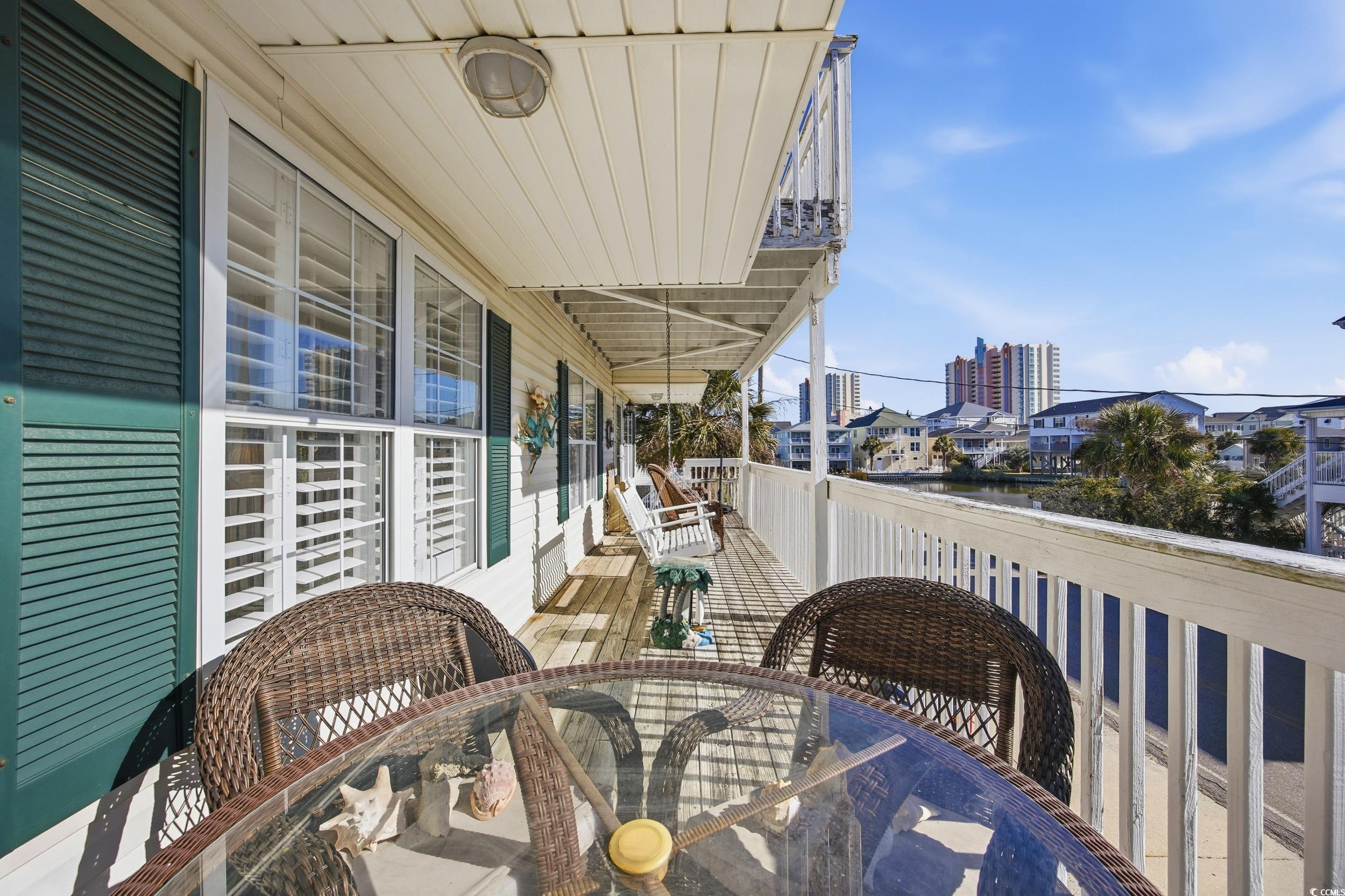 Balcony featuring outdoor dining space and a sunroom