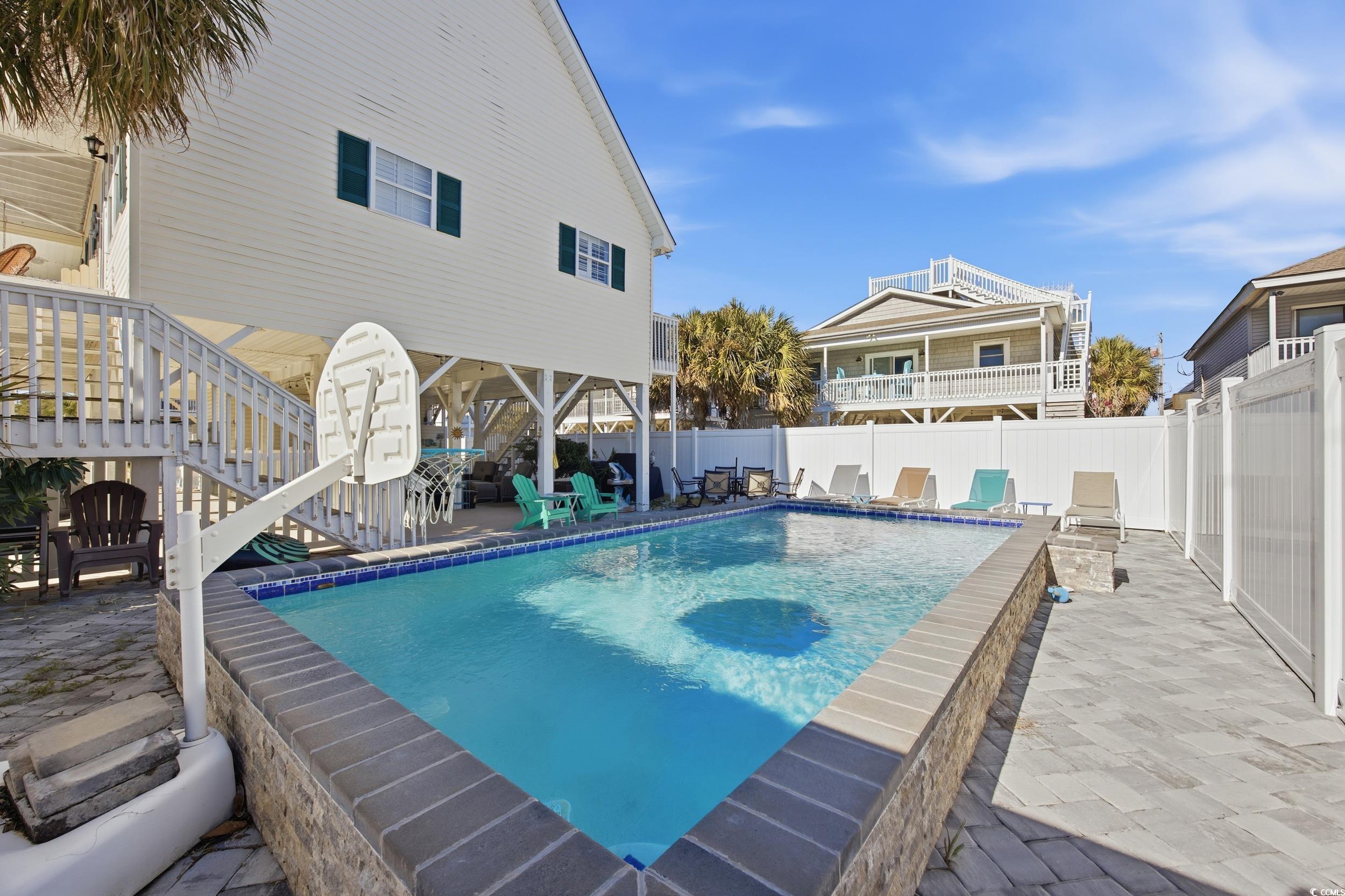 View of swimming pool with stairway, a patio area, and a fenced backyard