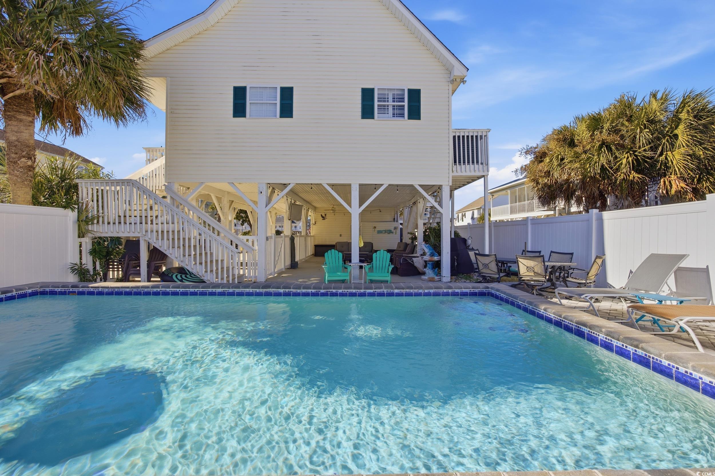 View of swimming pool featuring a fenced backyard, stairs, a patio area, and a wooden deck