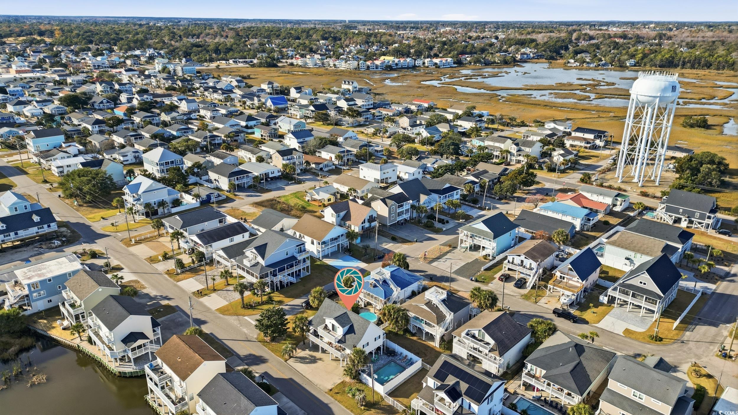 Aerial view of property and surrounding area with nearby suburban area and a large body of water