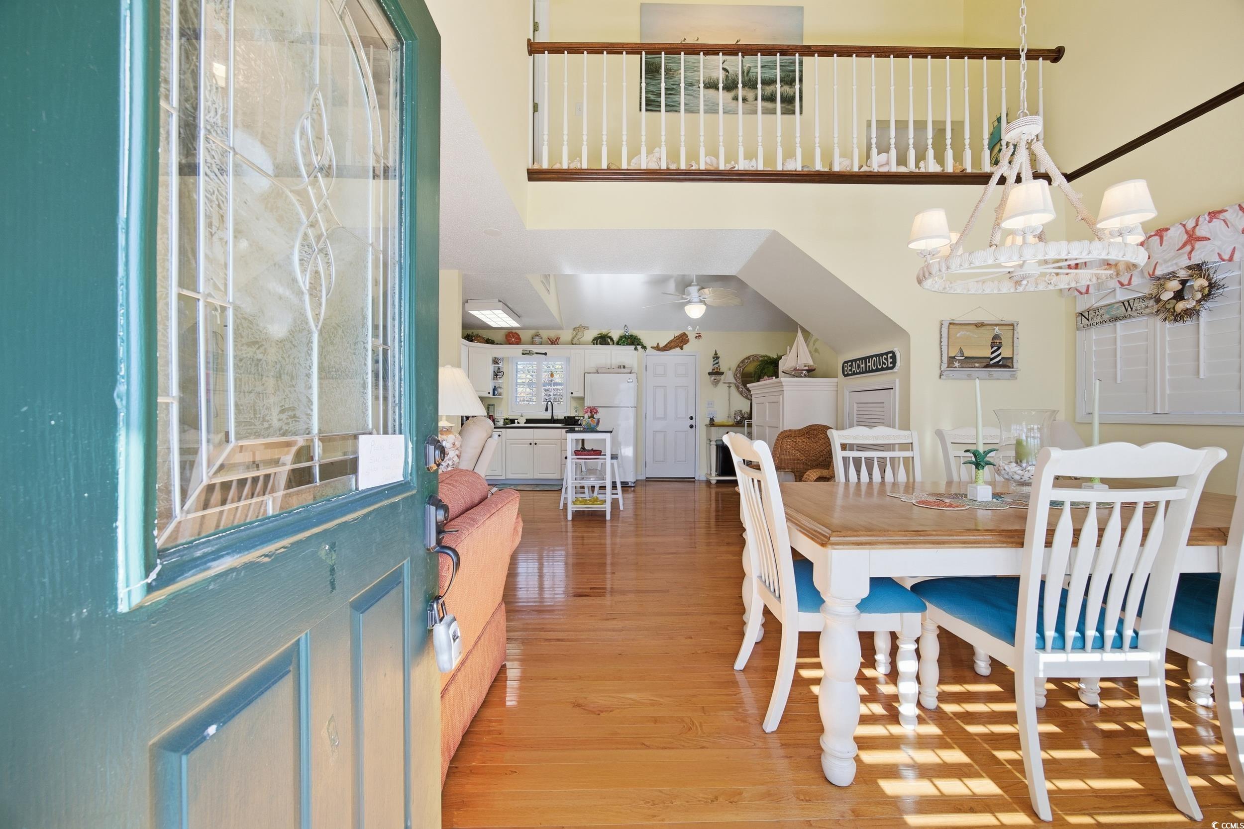 Dining space with a towering ceiling, light wood-style floors, a chandelier, and ceiling​​‌​​​​‌​​‌‌​‌‌‌​​‌‌​‌‌‌​​‌‌​‌‌‌ fan
