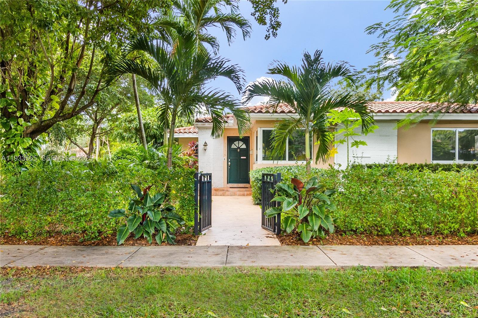 Located on a quiet, tree-lined street in North Gables just off Granada and Venetian Terrace, this well-maintained 4-bedroom, 2-bath home sits on an oversized corner lot of nearly 8,000 sq. ft. The home features a large living room with French doors opening to a private patio and landscaped side yard.Floor plan includes a primary suite off the dining area, two bedrooms and one bath in the front wing, and a flexible fourth bedroom with double French doors located off the family room — ideal for a guest suite or home office.Updated, all-white kitchen with Italian cabinetry flows into a bright breakfast area offering additional storage. Other features include impact windows, 2014 adjusted square footage, and a large one-car garage.Prime location close to Granada Golf Course, downtown Coral Gables, and top schools. Easy access to dining, retail, and cultural amenities.