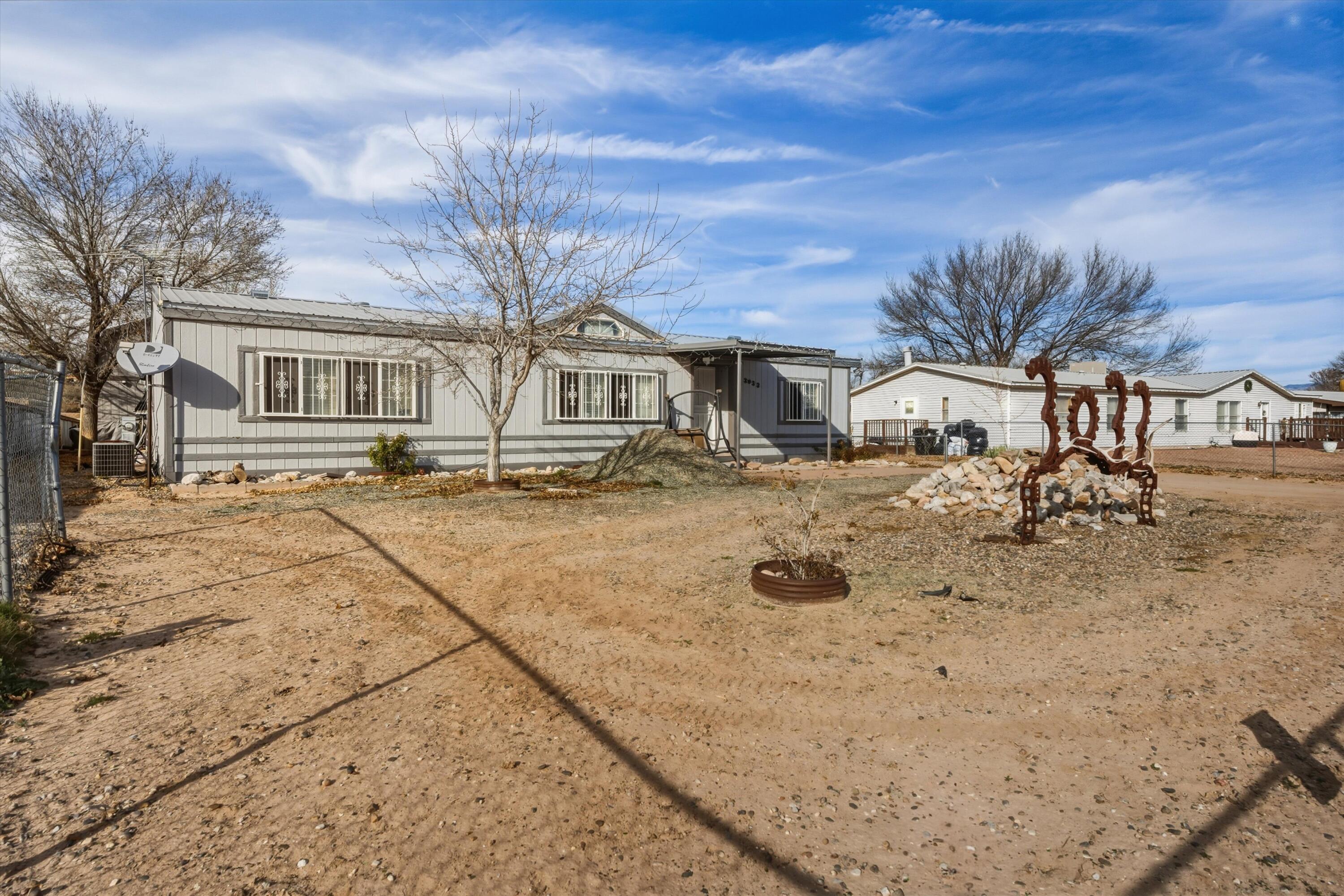 This three-bedroom, two-bathroom manufactured home is located in the South Valley, offering a comfortable living space on almost a half acre. This property is completely fenced in, suitable for horses or any of your outdoor desires with back yard access, storage sheds, and an impressive workshop. The layout is thoughtfully designed, with a spacious living area that flows into the kitchen and dining space, making it ideal for everyday living. Each bedroom provides ample room, while the two full bathrooms add convenience for families or guests. Surrounded by open skies and a relaxed neighborhood atmosphere, this is a great place to call home!