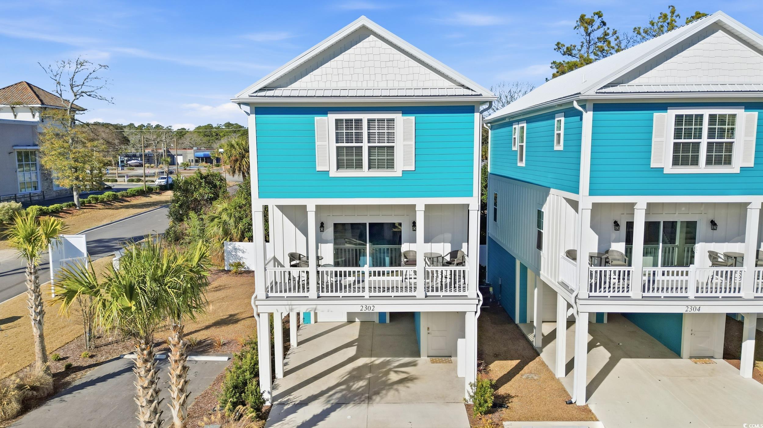 View of front of house with a carport, driveway, and covered porch