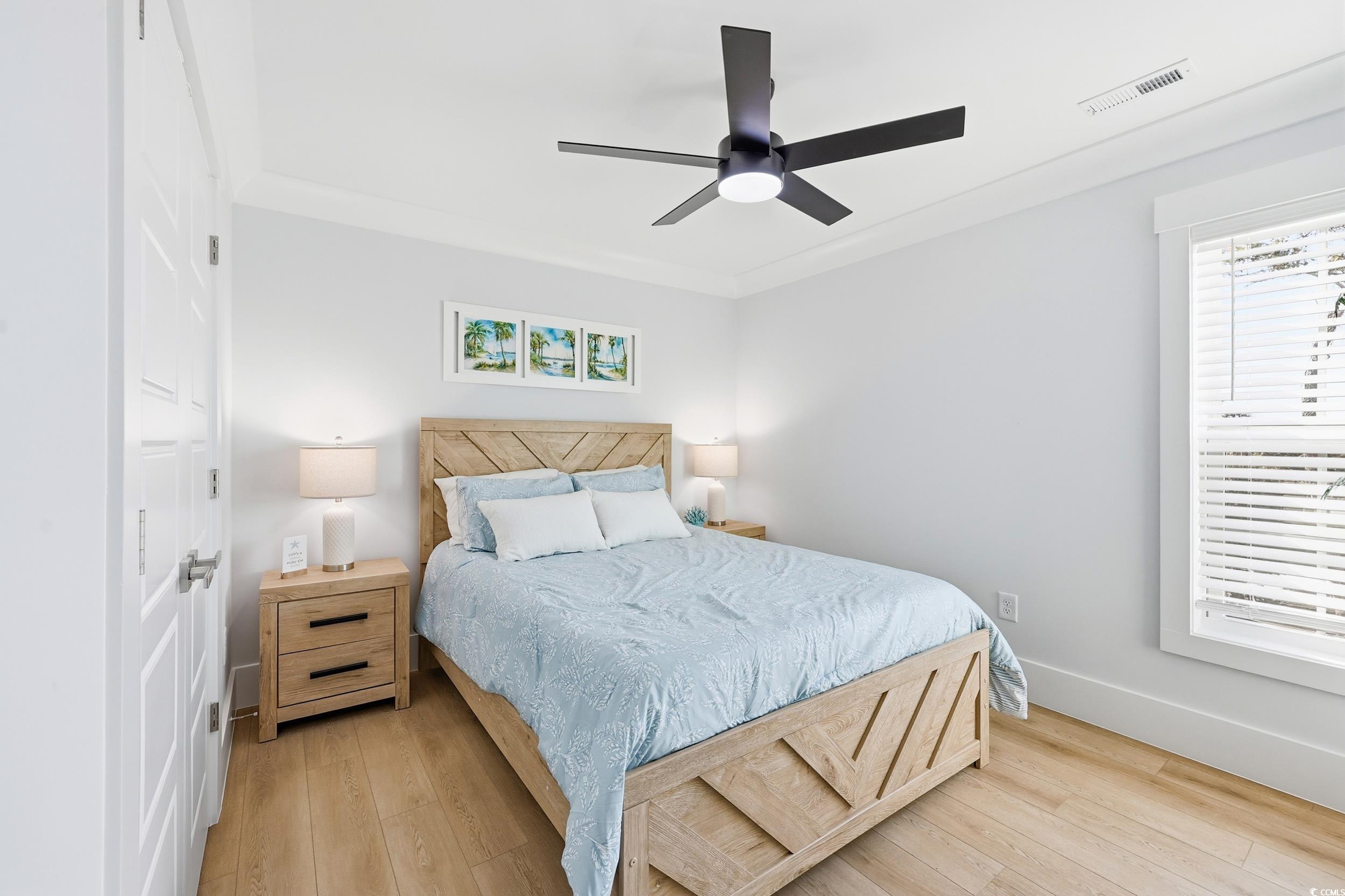 Bedroom featuring light wood-type flooring, ceiling fan, and crown molding