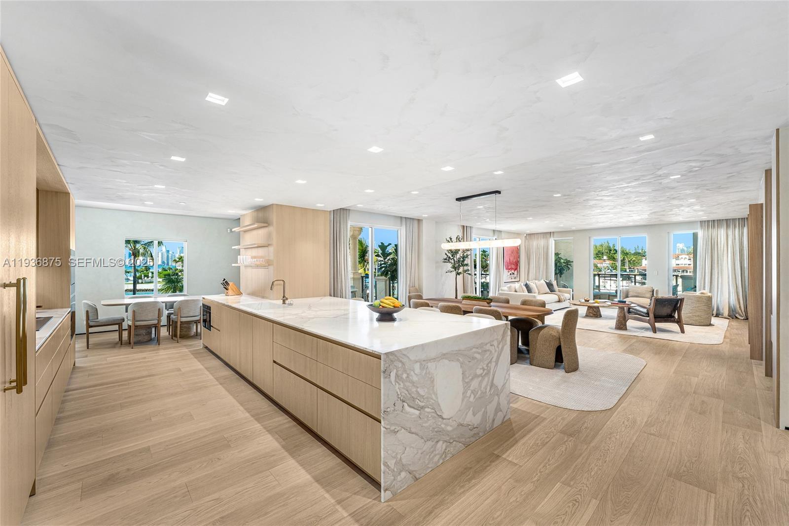 Expertly and beautifully renovated, this 2,744-SF residence with 3BR and 3.5BA overlooks Fisher Island’s inner marina. Features five terraces, a gated front entry, three side terraces with Biscayne Bay and Miami skyline views, and a marina-facing terrace. Interiors by Sensi Casa Design Studio create a cohesive turnkey home with a pivot entry door, wide-plank oak floors, Italian oak doors, limewashed walls and ceilings, and custom Pedini closets. The open living and dining areas include bespoke millwork, a bar, and terrace access. The Del Curto Italian kitchen offers a marble island, Wolf, Miele, and Sub-Zero appliances, plus a breakfast area. The primary suite has terrace access, a walk-in closet, & a spa bath. Two additional ensuite bedrooms also offer custom closets and terrace access.
