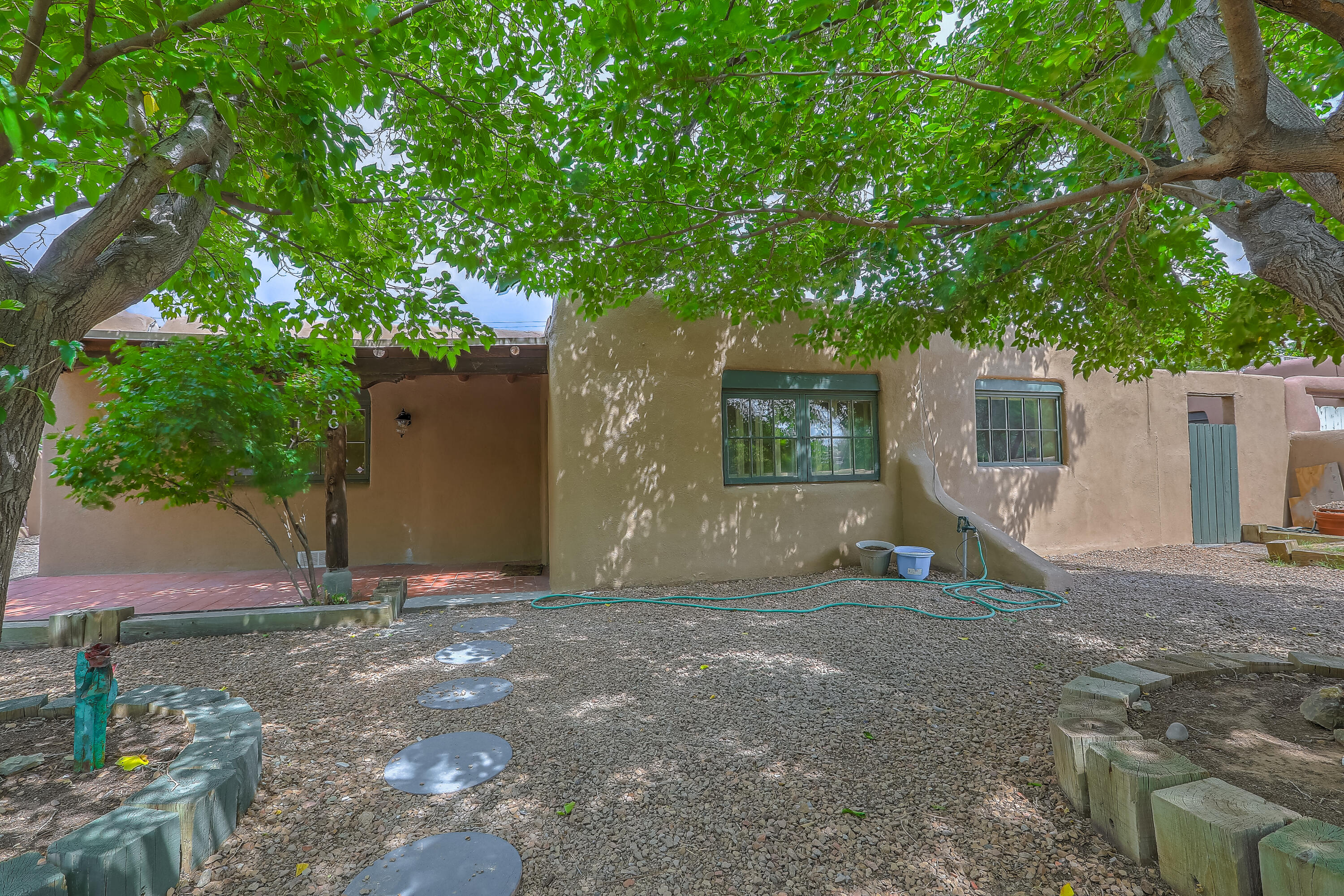 One-of-kind property in a one-of-kind location! This Watson adobe home is steps away from Tiguex Park, Old town, museums, the Abq Bio Park, shops and eateries. Incredible, walkable location on a private, tree-lined street. The home itself has been beautifully updated and lovingly maintained, while keeping it's old-world charm. Y'all will love the hardwood floors, tongue-in groove ceilings with large viga timbers, and the woodburning kiva fireplace. The open, eat-in kitchen boasts modern amenities such as stainless-steel appliances, and granite countertops. The screened in porch, covered patio and heated and cooled outbuilding provide additional flex spaces. If you want a home with authentic New Mexican character, this is the one you have been waiting for!