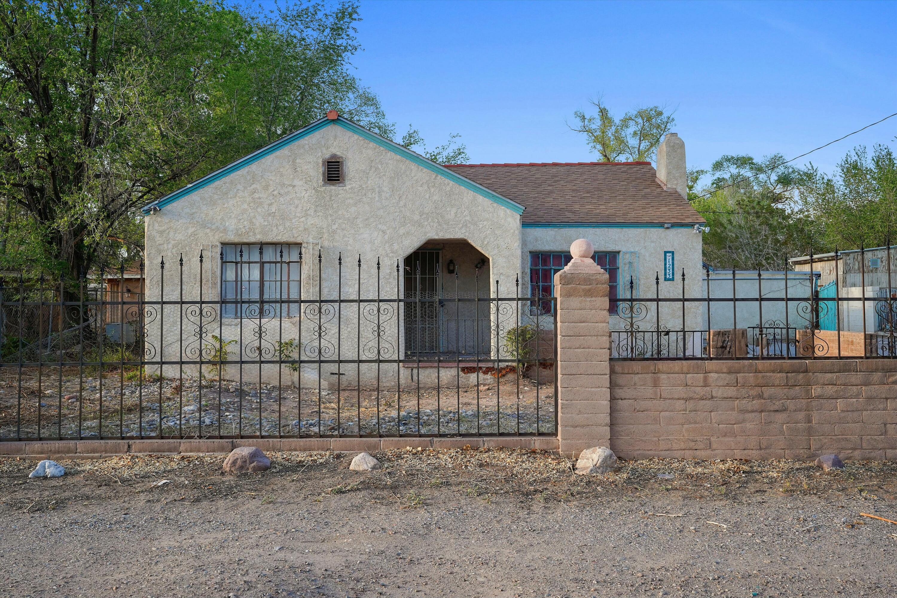 This spacious 4,030+ sq ft Southwest-style home in Albuquerque offers incredible potential with 3 bedrooms, 2.5 baths, and generous living areas ready for full renovation. Features include a wood-burning stove insert, second stove in the large family room, Saltillo tile, and 27 arches for added charm. Work from home in the double office with 4 phone lines. Outdoors, enjoy a built-in BBQ under a shade-giving Mulberry tree, a 25,000-gallon pool, two sheds, two compost bins, a fountain, and a garage. With solid bones and endless possibilities, this gardener's delight is a dream fixer-upper!