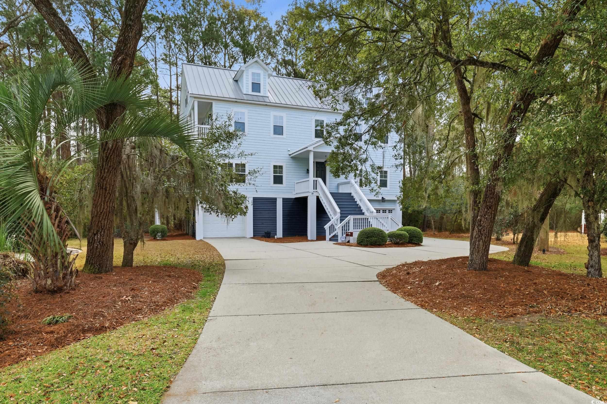 *TWO OPEN HOUSE OPPORTUNITIES, SATURDAY, MARCH 7th and SUNDAY, MARCH 8th* 49 Schooner Ct. in Waccamaw Trace at North Litchfield Beach invites you to live the coastal lifestyle fully furnished, move-in ready, and beautifully refreshed throughout. Unpack your bags, settle in, and start enjoying beach life from day one. Start your mornings on the front porch, coffee in hand, as the sun rises over the marsh. End your evenings there with dinner while the sky turns soft shades of pink and gold. The balcony off the second-floor primary suite offers a quiet retreat for reading, reflection, or simply taking in the view.  Set within a welcoming community where bikes and golf carts are part of daily life, everything feels close and easy. Step inside and notice freshly painted interiors, soaring ceilings, and gleaming hardwood floors that catch the light from every window. Hurricane-grade French doors in the living room, dining room, and upstairs primary suite flood the home with natural light while providing storm-ready peace of mind. New ceiling fans throughout keep the air moving in every season.  The first-floor blends living, dining, and kitchen areas into an open, welcoming space anchored by an updated gas fireplace the perfect gathering spot. The primary suite on this level features rich Brazilian cherry hardwood floors and a newly renovated spa-inspired bathroom. A half bath and laundry room complete this floor.  Upstairs, the second primary suite boasts its own renovated bathroom and a boutique-style custom closet with generous hanging space, plentiful drawers, and a built-in hamper. Durable, mop-safe luxury vinyl plank flooring on the stairs and throughout this level handles sandy feet with ease. A jack-and-jill bedroom and bath, plus a second laundry area, provide flexibility for family and guests.  The third floor opens into a large living area with a bonus room and half bath ready to become an office, game room, theatre, or additional bedrooms with endless possibilities.  Every detail is designed for comfort and ease: fully furnished and turnkey, an on-demand water heater for endless hot showers, a Wi-Fi-enabled garage door for smart access, a security system, lawn irrigation, a durable metal roof, and enclosed parking beneath. The home is elevator-ready.  Location brings it all together. A short bike ride or golf cart trip takes you to the wide sands of North Litchfield Beach, the Waccamaw Neck bike trail, or the community pool. Historic Charleston is close enough for a day trip, and Myrtle Beach's restaurants, entertainment, and attractions are just minutes away.  At 49 Schooner Ct., every day starts with sunrise walks, ends with evenings on the porch, and overflows with the freedom to explore, relax, and enjoy life along the coast.
