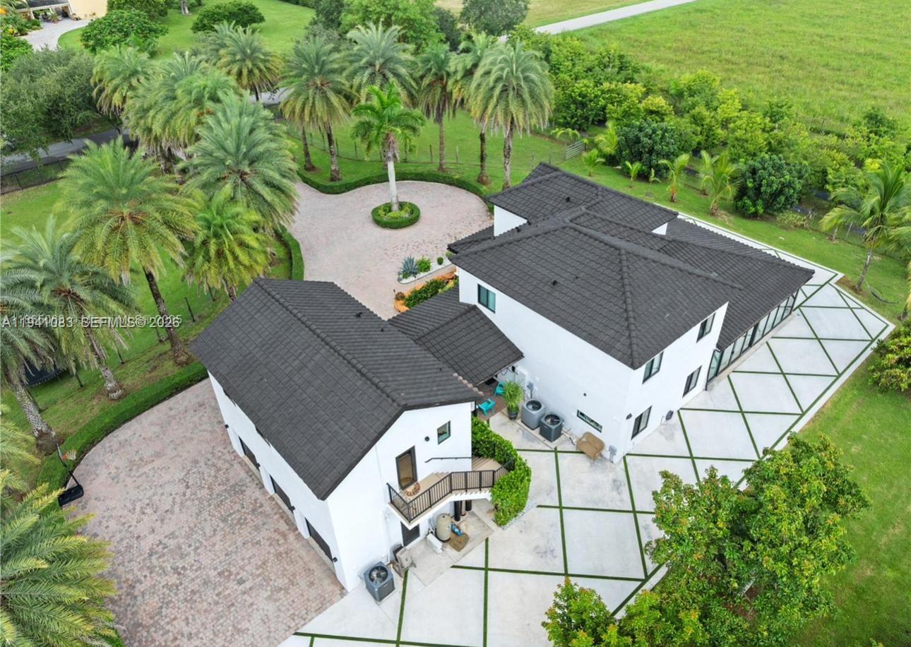 Experience the charm of country living with this stunning 4.6-acre modern estate in Homestead, FL. Built in 2007, this turn-key furnished single-family home offers 3,945 sq. ft. of living space with spacious interiors, high ceilings, and abundant natural light. The property is a true tropical paradise, boasting 623 mature fruit trees producing year-round, including soursop, mango, coconut, jackfruit, sugar apple, star fruit, dragon fruit, sapodilla, papaya, and guava. Featuring a circular driveway, covered parking, and additional vehicle space, it is surrounded by lush greenery for privacy and tranquility. Perfectly blending modern/contemporary design with comfort, and ideally located just minutes from major highways, shopping, and dining. Ready for immediate occupancy.