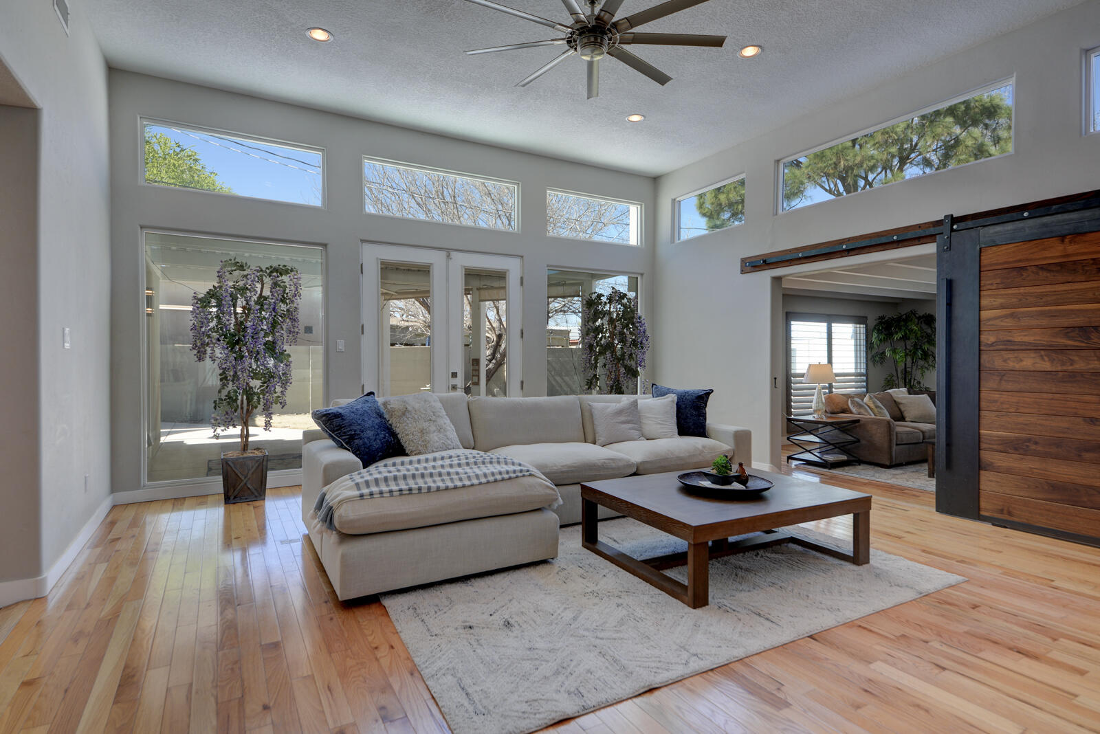 Experience sophisticated living in the prestigious Albuquerque Country Club! The living rooms are divided by a dramatic gas fireplace, plus a versatile bonus space ideal for a gym, office, or playroom w/Brazilian barn door for privacy complemented by plantation shutters. Abundant natural light fills the home. Rich oak & tile flooring extend throughout the home. The gourmet kitchen impresses w/custom soft-close cabinetry, quartz countertops, a center island & professional-grade appliances. A butler's pantry adds function with sink, wine fridge, walk-in pantry, folding counter & abundant storage. The primary suite offers a tranquil retreat w/ spa-inspired bath & walk-in closet. A private casita (209/sf) with 1/2 bath and mini split. Owned solar enhances efficiency and long-term savings!