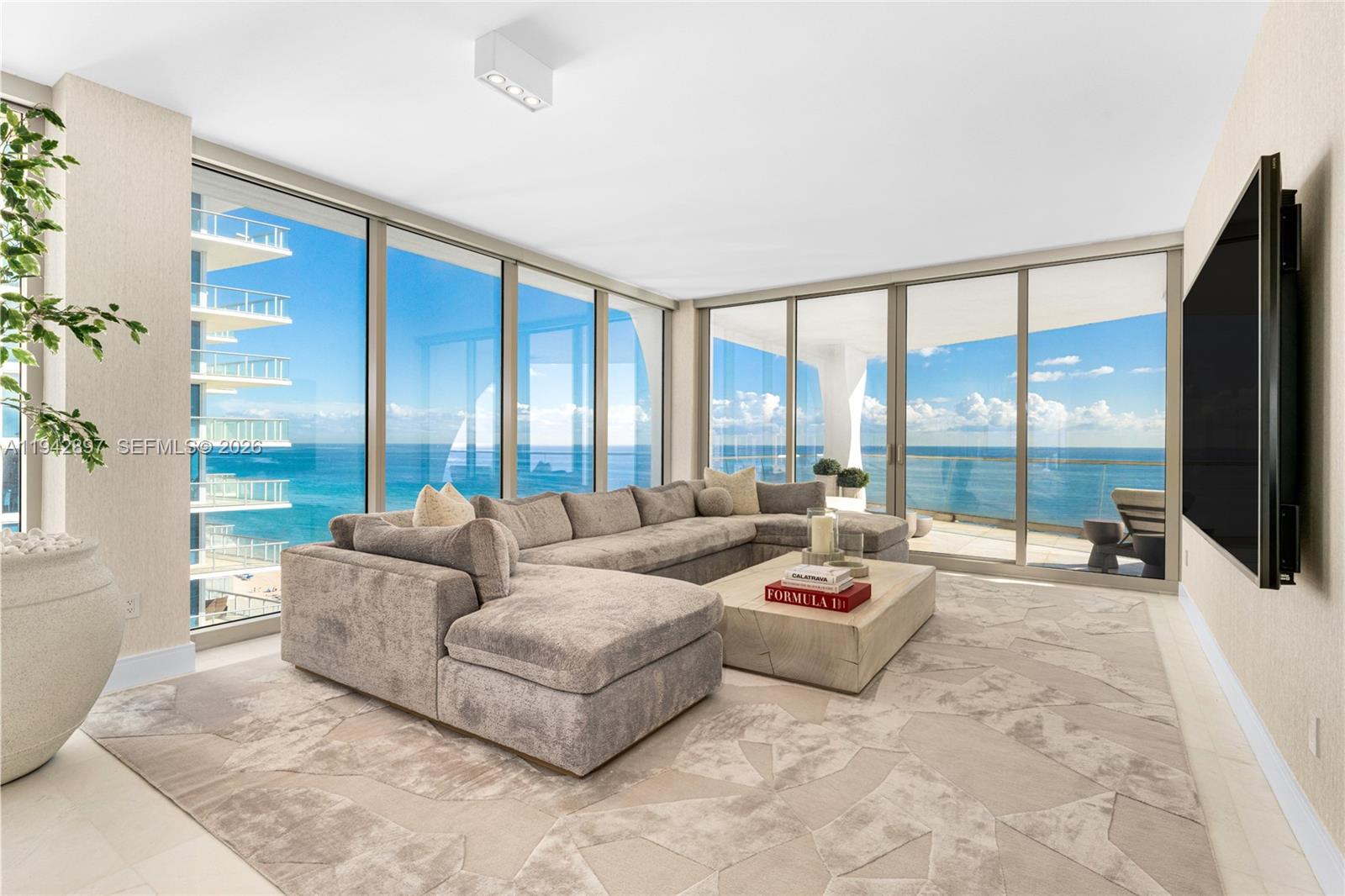 This extraordinary oceanfront residence has been fully renovated by Douglas Graneto Design and is offered completely turnkey, presenting a rare opportunity to acquire a meticulously curated, move-in-ready home. The 4-bedroom, 5.5-bath corner residence features a coveted flow-through layout with sweeping oceanfront vistas by day and breathtaking 180-degree city sunset views by night.Every detail has been thoughtfully selected to reflect the highest level of craftsmanship and refinement. Honed marble flooring and marble-clad bathrooms create a timeless, serene foundation throughout the home. Custom-designed couches, Art and Loom bespoke rugs, and brand-new Artefacto coffee table and balcony furnishings elevate each living space with understated sophistication.The designer kitchen and dining experience are enhanced by a custom high-end dining table, Artistic Frame chairs, and a striking Cuff Studio chandelier, complemented by curated Pucci and Bone Simple lighting throughout the residence. Walls are adorned with exclusive Holly Hunt wall coverings, adding depth, texture, and quiet luxury.Impeccably designed and beautifully executed, this residence seamlessly blends comfort, artistry, and modern elegance—an exceptional offering for the most discerning buyer seeking true ultra-luxury oceanfront living.