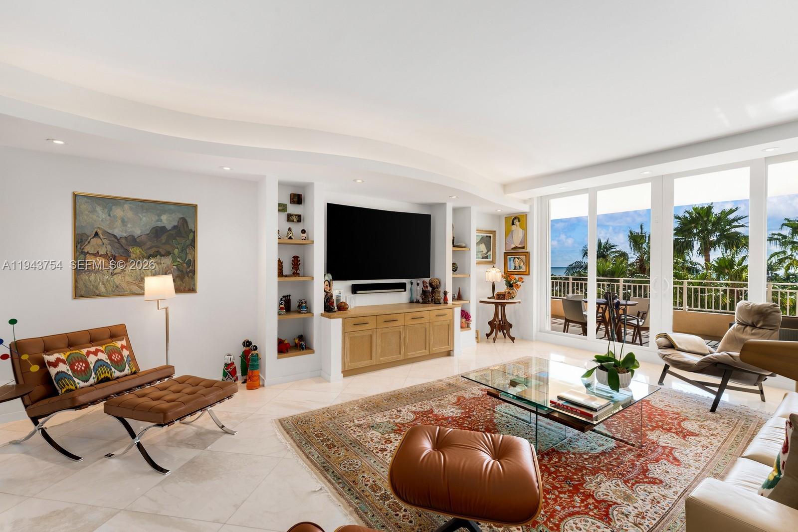 Unique opportunity to own a custom-designed and remodeled 2,605 SF residence in The Ocean Club’s most desirable beachfront building, Ocean Tower Two. Originally a three-bedroom, the residence has been reimagined as a spacious, light-filled two-bedroom with library/den and generous living and dining areas.Architectural curves, rounded built-in shelving, and layered lighting define the home’s distinctive character. Custom millwork—harmoniously carried throughout the kitchen, library, closets, and bookshelves—adds warmth and a cohesive aesthetic. Polished marble floors, recessed and cove lighting, and refined wall surfaces create an elegant, modern interior ideal for displaying art and furnishings. The library features an electric fireplace, offering an inviting retreat.The open kitchen integrates seamlessly with the living areas and features custom cabinetry, an island cooktop, and Thermador appliances. The primary suite offers a tranquil retreat with refined finishes and beautiful views, while the primary bath is finished in marble and glass with custom vanities and a walk-in shower. Ocean views are enjoyed from within the main living areas, as well as from two spacious terraces overlooking lush tropical gardens, resort pools, and the Atlantic.The Ocean Club provides luxurious resort-style living: beach, pools, restaurants, fitness center with ocean views, spa, salon, playground, playrooms, 7 Har-Tru tennis courts, 3 padel courts, security and valet services.